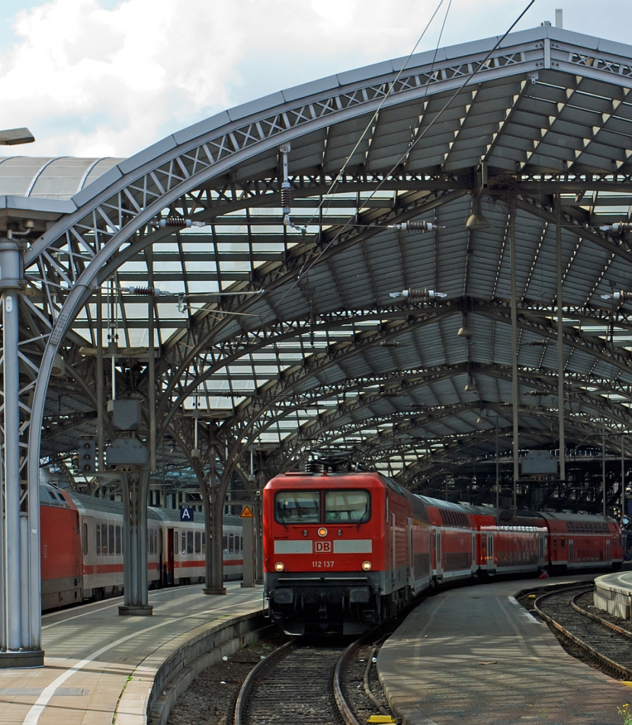 112 137  mit dem RE 7 - Rhein-M�nsterland-Express (Krefeld-K�ln-Wuppertal-Hagen-M�nster) f�hr vom Hbf K�ln weiter in Richtung M�nster.

Die 112.1 wurde unverhofft zu einem Symbol f�r die Deutsche Einheit, denn sie war die erste Lokomotivbaureihe, die von beiden Bahnverwaltungen gemeinsam beschafft wurde. Man kam �berein, dass DR und DB jeweils 45 Loks der leicht verbesserten Baureihe 112.1 bei der AEG bestellen w�rden (die AEG hatte zwischenzeitlich ihr 1946 enteignetes Werk in Hennigsdorf wieder �bernommen). Dies erfolgte haupts�chlich aus arbeitsmarktpolitischen Gr�nden zur St�tzung des Hennigsdorfer Werkes, denn die Bundesbahn h�tte lieber eine 200 km/h schnelle und universell verwendbare Lok in aktueller Drehstromtechnik nach Art der Baureihe 120 beschafft