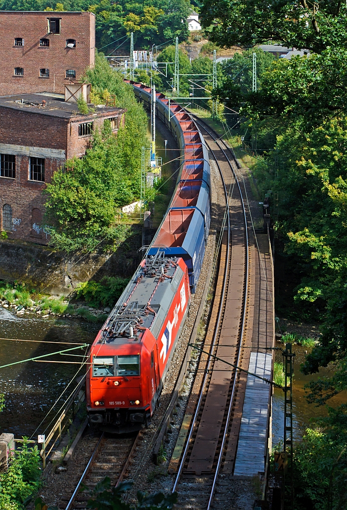 185 589-9 der HGK (H�fen und G�terverkehr K�ln AG) mit einem sehr langen Ganzzug von leeren VTG Selbstentladewagen (Falns) und am Schluss waren dann noch 2 Class 66 (JT42CWR) Lokomotiven der Ascendos Rail (vormals CBRail), hier am 19.08.2012 auf der Siegbr�cke kurz vor dem M�hlburg-Tunnel in Scheuerfeld/Sieg. Der G�terzug f�hrt in Richtung K�ln.