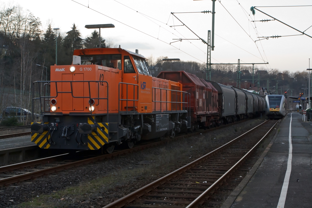 Betzdorf/Sieg am 04.02.2012: Die Hellertalbahn (Stadler GTW 2/6) ist auf Gleis 102 eingefahren, nun kann gleich auf Gleis 103 die Kreisbahn Siegen-Wittgenstein  (KSW) mit Lok 42, eine Vossloh G 1700 BB (F.-Nr. 1001108, Baujahr 2001) mit beladenen Coil-G�terzug in Richtung Herdorf losfahren. 