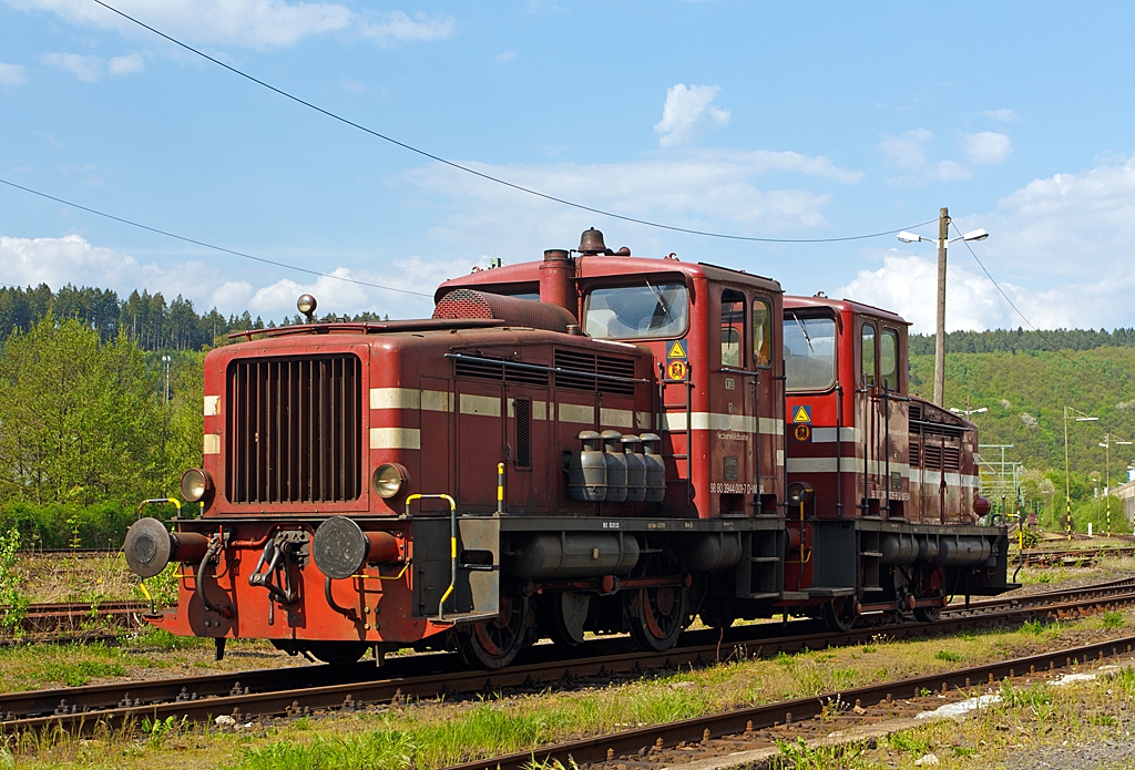 Die Westerwaldbahn (WEBA) Lok 1 und 3 (V 26) am 06.05.2013 in Scheuerfeld/Sieg. 

Die Jung Loks vom Typ R 30 B wurden bei der Firma Jung in Kirchen/Sieg 1956 und 1957 (Fabriknummer 12102 bzw. 12748) gebaut und als V 26.1 bzw. V 26.3 an die WEBA geliefert. Die V 26.1 war �brigens die erste Maschine dieses Typs die Jung gebaut hatte.
Hier in Doppeltraktion abgestellt, in dieser Einsatzform werden sie F�hrerhaus an F�hrerhaus gekuppelt, an den F�hrerhausr�ckw�nden sind �bergangsm�glichkeiten zur jeweils anderen Maschine.
Die WEBA hatte 4 dieser Jung R 30 B Loks, diese zwei Loks sind heute noch als Reserveloks erhalten geblieben. Sie haben die NVR-Nummer 98 80 3944 001-7 D-WEBA bzw. 98 80 3944 005-8 D-WEBA.
Die Maschinen besitzen ein hydraulisches Getriebe (diesel-hydraulische Lok),  die Kraft�bertragung erfolgt vom Getriebe mittels Blindwellen �ber Treibstangen auf die R�der. 

Technische Daten: 
Achsformel: B
L�nge �ber Puffer:  7.680 mm
Achsabstand: 3.000 mm
Gewicht der Lok: 28 t
H�chstgeschwindigkeit: 46 km/h (23,4 km/h im Rangiergang)