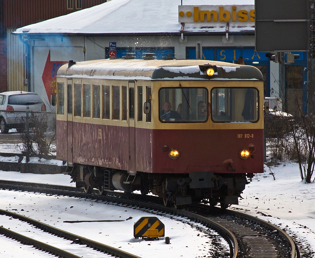 Ein Unikat mit einer sehr wechselhaften Geschichte, der Schmalspur (1.000 mm) Dieseltriebwagen 187 012 der HSB, ex T15 der MEG, ex WEG T35, ex VT3 der Langeooger Inselbahn, 
hier am 23.03.2013 als Zug-Nr. 8901 (morgendliche erste Zug; 7:45 Uht)  bei der Ausfahrt aus dem Bf Wernigerode nach Drei Annen Hohne.


Im Jahre 1955 wurde der heutige 187 012 von Waggonfabrik H. Fuchs, Heidelberg unter der Fabriknummer 9107, f�r die Mittelbadische Eisenbahnen AG, gebaut. Er wurde auf der Strecke Zell -Todtnau (Fr�her S�ddeutsche Eisenbahn Gesellschaft) als T15 der MEG eingesetzt. Die MEG war rechtlich ein Vorg�nger der SWEG-S�dwestdeutschen Verkehrs-AG.

Dieser Triebwagen ist ein Unikat. 
An beiden Stirnseiten des Triebwagens gab es T�ren f�r den �bergang zu den mitgef�hrten Wagen. Das F�hrerpult fiel dementsprechend schmal aus. Die beiden Motoren wurden in Unterflurbauweise aus dem Wagenkasten verbannt, sodass ein sehr ger�umiger Fahrgastraum entstand. Er wurde mit je zwei Faltgittert�ren an jeder Wagenseite gebaut. 

Leider wurde die 18 km lange Strecke Zell - Todtnau wegen Unwirtschaftlichkeit am 24. September 1967 geschlossen. Den T15 der MEG hat man zur Stammstrecke der MEG B�hl - Schwarzach verbracht. Doch f�r diese Strecke erwies sich der T15 als v�llig ungeeignet, denn er war einfach zu lang, f�r die dortigen B�gen. 
Der MEG gelang es, einen Kunden f�r den Triebwagen zu finden. Die W�rttembergische Eisenbahn Gesellschaft kaufte ihn 1968 f�r ihre Schmalspurbahn auf der schw�bischen Alb - der Strecke Amstetten   Laichingen. Hier wurde er nun zum T 35 der WEG. Bis 1972 kam er dort, jedoch nur selten, zum Einsatz. 
Er wurde umgebaut. Aus einer Stirnseite wurde die �bergangst�r entfernt und der Triebwagen behielt nur einen Motor - der zweite Motor wurde entfernt. Der WEG T35 blieb auch nach dem Umbau ein Reservefahrzeug, weil er auf dieser Bahn nicht f�r den G�terverkehr eingesetzt werden konnte. 
Die WEG sah sich nun ihrerseits nach einem weiteren K�ufer f�r den T35 um und verkaufte ihn 1976 an die Langeooger Inselbahn. 
Doch bevor der s�ddeutsche Triebwagen zum  Insulaner  wurde, arbeitet man ihn in der Bremer Waggonbau GmbH gr�ndlich auf. Er erhielt zwei neue Motoren B�ssing (Braunschweig) U11 D mit je 155 kW (210 PS).  Das mechanische RENK-Getriebe wurde durch zwei hydromechanische Differentialwandler-Getriebe vom Typ VOITH 501 (Bauart 380 U+S 320) ersetzt. Die noch verbliebene �bergangst�r an der Frontseite wurde zudem auch entfernt. Auf einer Wagenseite wurden die Faltt�ren ausgebaut. 

Auf Langeoog wurde er zum T3 und fuhr im Juni 1976 erstmalig �ber die Insel. Dort verrichtete er viele Jahre klaglos seinen  windigen  Dienst. Aber es sollte nicht die letzte Etappe seiner Odyssee durch Deutschland gewesen sein. 
Am 13. April 1995 unterzeichneten die HSB den Kaufvertrag f�r drei Triebwagen der Langeooger Inselbahn - darunter den des T3 (Langeoog). 
Den Weg in den Harz legte der angehende 187 012 auf einem Tieflader bis Halberstadt und von dort per Schiene im Mai 1995 zur�ck. F�r seinen Einsatz im Harz waren jedoch erneut einige Umbauten erforderlich. Besonders wichtig hierbei war die Wiedereinrichtung von T�ren auf beiden Wagenseiten, da sich die Bahnsteige der HSB sowohl rechts als auch links in Fahrtrichtung befinden. Im Zuge dieser Ma�nahme wurden die alten Faltt�ren entfernt und durch T�ren neuerer Bauart ersetzt. 
Der 187 012 wird heute vorwiegend im �ffentlichen Personennahverkehr zwischen Nordhausen und Ilfeld (Harzquerbahn), sowie zwischen Wernigerode nach Drei Annen Hohne (Brockenbahn) eingesetzt.


Technische Daten:
Hersteller: Waggonfabrik H. Fuchs, Heidelberg
Fabriknummer: 9107
Spurweite: 1.000 mm 
Achsanordnung: B' B' dh (Original B' B' dm) 
L�nge �ber Puffer: 16.130 mm
Fahrzeugh�he: 3.360 mm 
Achsabstand im Drehgestell: 1.860 mm
Drehzapfenabstand: 11.700 mm
Leergewicht: 23,3 t 
kleinster befahrbarer Gleisbogen: 50m
H�chstgeschwindigkeit: 60km/h
Sitzpl�tze: 48
Stehpl�tze: 40

Motor/Leistung: 
2 St�ck B�ssing 6-Zylinder-Unterflur-4Takt-Diesel mit Direkteinspritzung.
Typ:U11 D/210 
Leistung: je 155 kW (210 PS) bei 2.100 U/min
Hubraum:11.581 cm3
Zylinderanordnung: Reihe, liegend
K�hlung: Wassergek�hlt
(Original 2 Motoren � 132 kW bzw. 180 PS)

Getriebe: Voith Differentialwandlergetriebe (hydrodynamisch) Typ 501 Bauart 380 U+S 320

Bei diesem dieselhydraulischen Triebwagen hat jedes Drehgestell  seine eigene Antriebsanlage, Dieselmotor in Unterflurbauweise und hydrodynamisches Getriebe.
