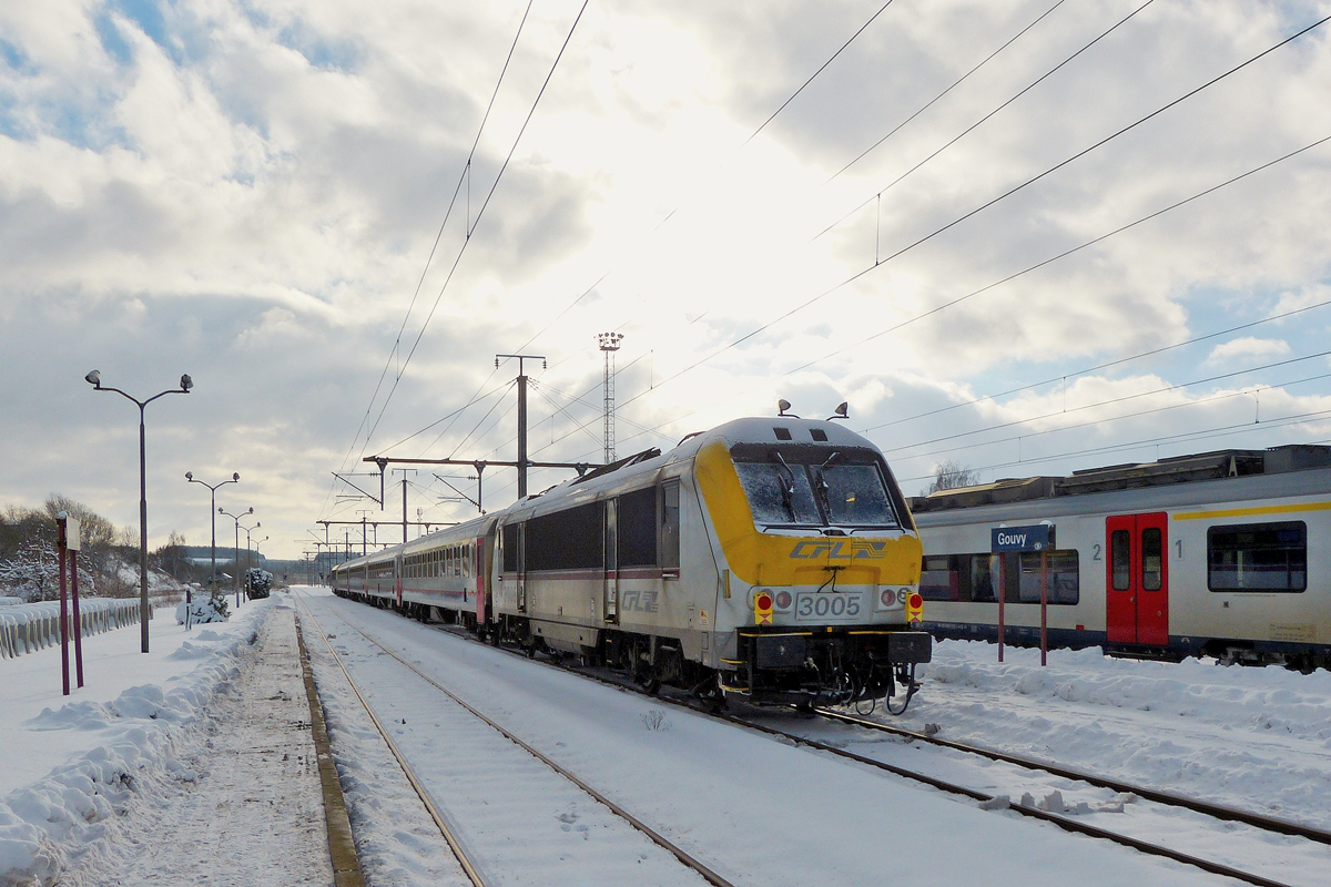. Ungew�hnliche Zugkomposition - Der IR 110 Liers (?) - Luxembourg verl�sst den Bahnhof von Gouvy mit der 3005 im Schlepp. Wahrscheinlich kam der Zug nicht aus Liers, da das Gleis hinter dem Zug noch schneebedeckt war. Etwas sp�ter rangierte ein Doppeleinheit SNCB Desiros in Gouvy (an einem Sonntag sehr ungew�hnlich), sodass ich vermute, dass diese beiden Z�ge die Fahrg�ste zum liegengebliebenen IC gebracht hatten. (Hans) 