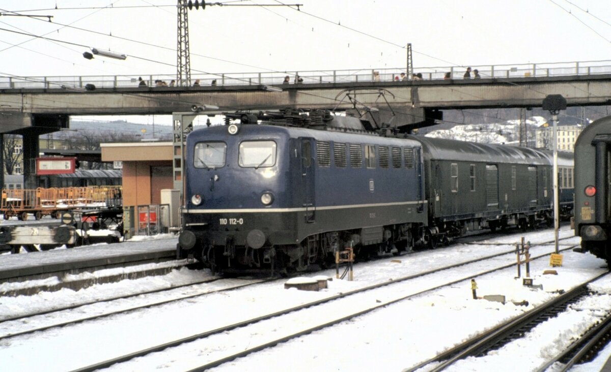 110 112-0 mit Packwagen Dms 905 in Ulm am 30.11.1980.