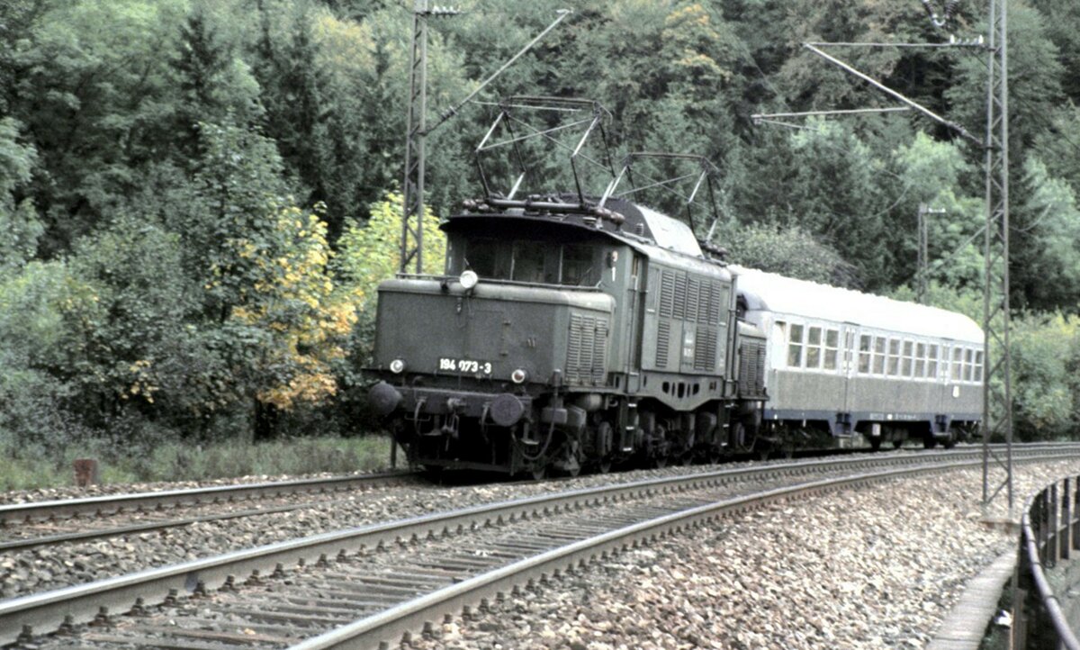 194 073-3 mit Schülerzug auf dem Mühltalfelsendamm der Geislinger Steige am 06.10.1984. Es müssen Herbstferien sein, da der Zug nur einen Wagen hat.