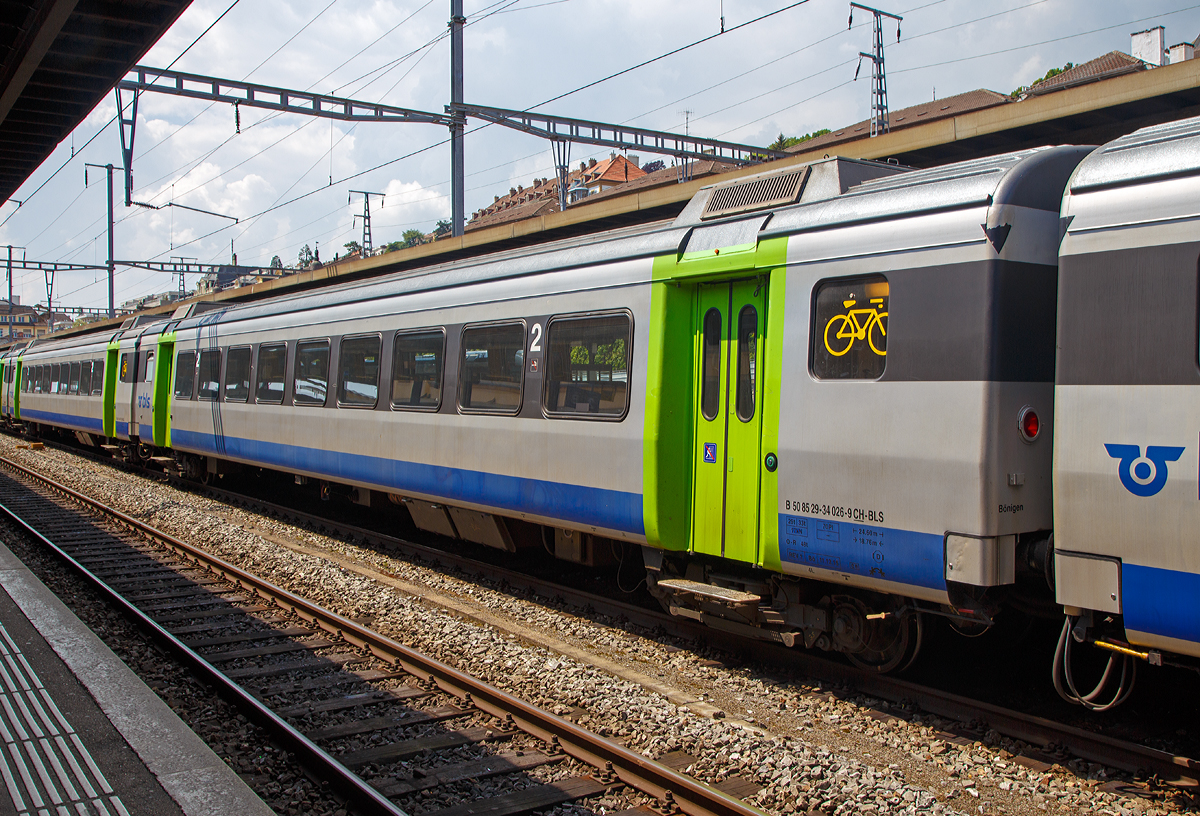 
BLS  2. Klasse Großraumwagen B 50 85 29 - 34 026-9 CH BLS ein Einheitswagen III (EW III) eingereiht am 18.05.2018 in einem BLS EWIII -  Pendelzug im Bahnhof Neuchâtel.

Die Einheitswagen III wurden 1972 bis 1975 gebaut und ab 1975 als Swiss Express mit der unverwechselbaren orange-hellgrauen Lackierung als Städteschnellzüge (heute InterCity) St. Gallen–Genève eingesetzt. Ihre Höchstgeschwindigkeit beträgt 140 km/h und sie waren konstruktiv für den Einsatz von Neigetechnik vorbereitet, die Seitenwände sind dafür auch nach oben hin einwärts geneigt gebaut worden. Sie waren die erste größere Serie klimatisierter Wagen in der Schweiz. Die 29 bis 30 Tonnen schweren Wagen erwiesen sich trotz dieser modernen Merkmale im täglichen Einsatz jedoch als nicht zufriedenstellend.

Es wurden insgesamt 72 Wagen gebaut. Die verbliebenen 57 Wagen wurden per Fahrplanwechsel 2004 an die BLS Lötschbergbahn verkauft und danach im Innenraum modernisiert. Die BLS ließ noch je zwei A-Wagen zu Zweitklasse-Steuerwagen und zu Endwagen umbauen. Somit existieren insgesamt neun Steuerwagen. Bis Dezember 2004 waren alle Wagen in den neuen BLS-Farben lackiert worden und seither werden sie im RegioExpressverkehr Bern–Langnau–Luzern und Bern–Neuchâtel eingesetzt. Im Gegenzug kauften die SBB die Einheitswagen IV der BLS. Von 2004 bis 2010 trugen die Wagen BLS-UIC-Nummern (50 63 …), seither tragen sie TSI-Nummern mit dem Landescode 85, die nicht umgebauten Fahrzeuge haben dabei wieder ihre alten Nummern erhalten. 

Ein sechsteilige Pendelzug- Komposition bietet 320 bis 343 Sitzplätze, die Wagenübergänge sind dabei stufenlos begehbar. Geschwindigkeiten von bis zu 140 km/h garantieren zudem attraktive Fahrzeiten.

TECHNISCHE DATEN:
Spurweite: 1.435 mm (Normalspur)
Wagenlänge über Puffer:  24.600 mm
Drehzapfenabstand: 18.760 mm
Eigengewicht: 29 t
Sitzplätze: 70 in der 2. Klasse
Besonderheit: Fahrradabteil