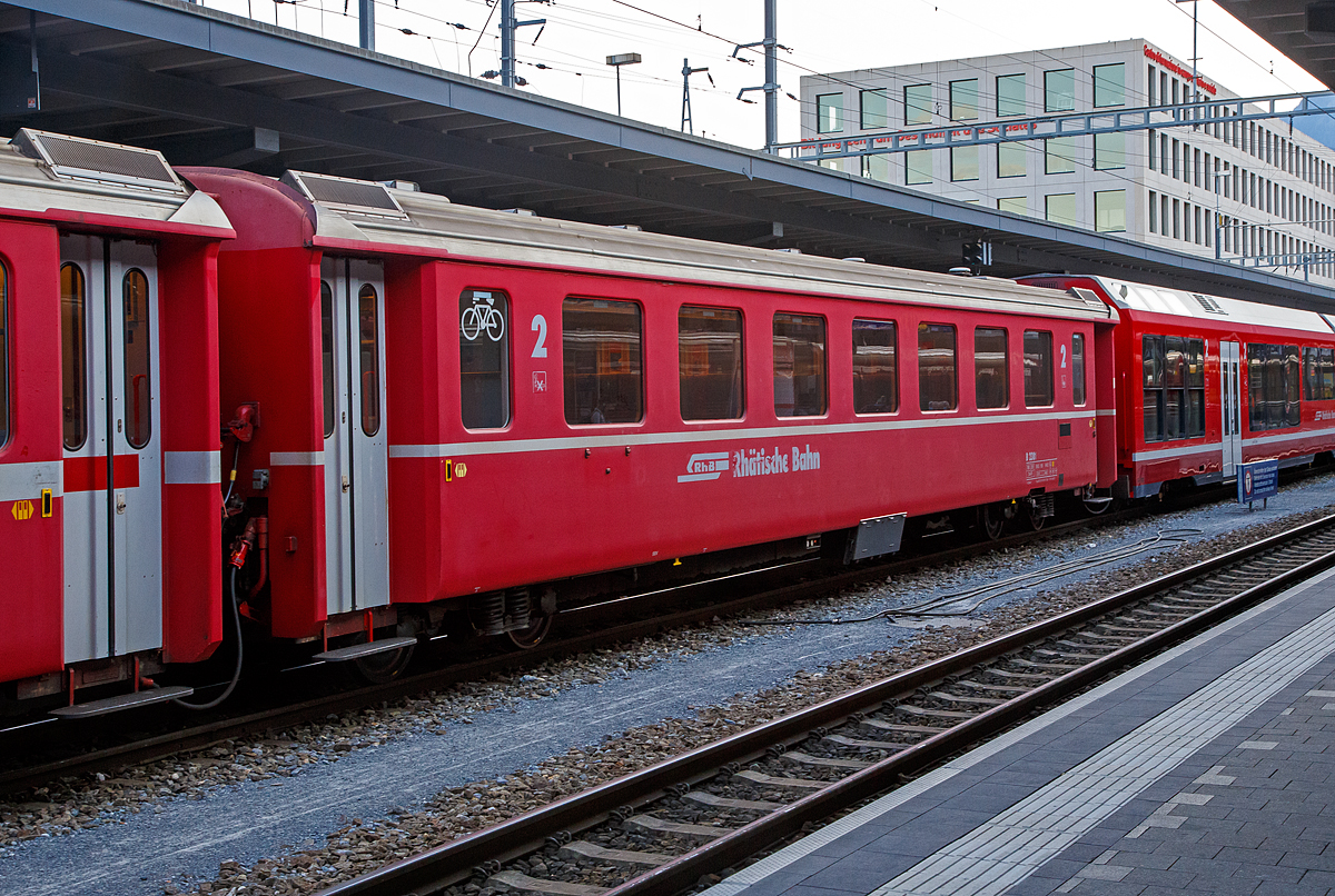 Der 4-achsige Personenwagen RhB B 2381, ein langer  2.Klasse Einheitswagen II (FFA EW II) mit Aluminiumwagenkasten am 06.09.2021 im Zugverband im Bahnhof Chur.

Gestiegene Fahrgastzahlen und Komfortanspr�che veranlassten die RhB, das bew�hrte Konzept des Einheitswagen I nach etwa einem Jahrzehnt zu �berarbeiten und den sogenannten Einheitswagen II (EW II) mit der Industrie zu entwickeln. Mehr als 60 Fahrzeuge dieser Serie konnten �ber einen Zeitraum von acht Jahren beschafft werden.  Von diesen 2.Klasse Wagen in der langen Ausf�hrung waren es alleine 40 St�ck (B 2374–83, 2421–50)

Als Verbesserung gegen�ber den EW I gelten neue Drehgestelle vom Typ SWP 74, der vergr��erte Sitzteiler (1.780 mm) in der 2. Klasse, get�nte Doppelverglasung und ein verbessertes Heizungs- und L�ftungssystem (�Hagenuk�). Trotz neuer Stoffbez�ge in der zweiten Wagenklasse, die Anfang der neunziger Jahre die roten und gr�nen Kunststoffsitzbez�ge abgel�st haben, wirkt das Interieur dieser Fahrzeuge heute gegen�ber den modernisierten EW I etwas altmodisch. Folgerichtig hat die RhB mit einem umfangreichen Refit-Programm begonnen. Neben einem modernen geschlossenen Toiletten-System erhalten diese Wagen, Dachklimager�te, ein neues Fahrgast-Informationssystem mit Innen- und Au�enanzeigen. Ferner wird die Inneneinrichtung zeitgem�� gestaltet.

TECHNISCHE DATEN:
Baujahre: 1976 bis 1980 (dieser 1976, Umbau 2004)
Hersteller:  Flug- und Fahrzeugwerke Altenrhein AG (FFA)
Hersteller Drehgestelle: Schindler Waggon Pratteln (SWP) 
Spurweite: 1.000 mm
Anzahl der Achsen: 4
L�nge �ber Puffer: 18.500 mm
Drehgestellbauart: SWP 74
Sitzpl�tze: 54 (2.Klasse)
Eigengewicht: 16,0 t
Max. Gesamtgewicht: 20 t
zul�ssige Geschwindigkeit: 90 km/h
Lauff�hig: StN (Stammnetz) / MGB (Matterhorn Gotthard Bahn)

Auf der Berninabahn ist ein Einsatz dieser langen Wagen nicht m�glich. Diese w�rden dort bedingt durch die teilweise engeren Gleisb�gen entgleisen.
