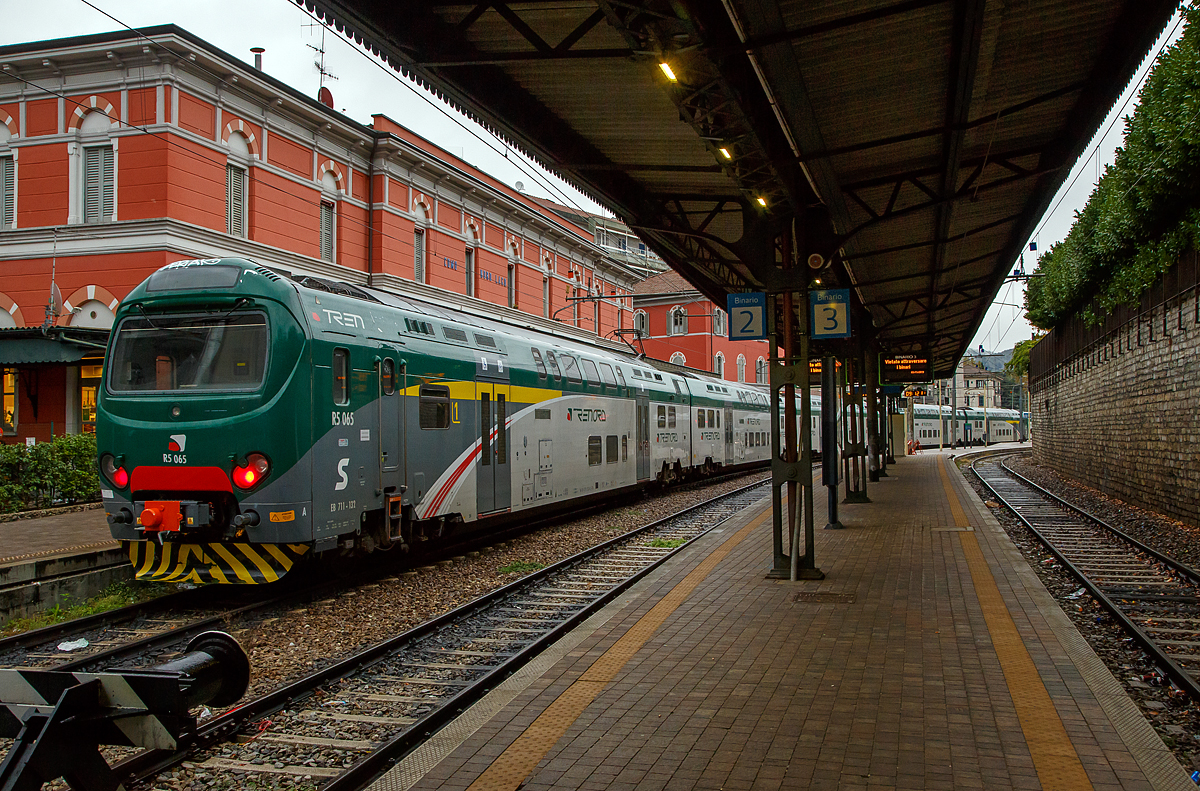 
Der fünfteilige Treno Servizio Regionale (TSR) R5 065 bzw. EB 711 -132 (auch geführt als ALe 711) steht am 03.11.2019 im FN (Ferrovie Nord Milano) Bahnhof Como Lago (oft auch Como Nord Lago bezeichnet) zur Abfahrt bereit. 

Der Treno Servizio Regionale (TSR) bzw. FS ALe 711 / ALe 710  ist ein italienischer Doppelstock-Triebwagen-Zug. Er wird unter anderem von Trenord und Trenitalia im S-Bahn-Verkehr eingesetzt. Entwickelt wurde das elektrisch angetriebene Fahrzeug von AnsaldoBreda, heute Hitachi Rail Italy. Ein Zug wird aus 3 bis 6 Triebwagen zusammengestellt.

Der Treno Servizio Regionale (TSR) ist eine Weiterentwicklung der Treno Alta Frequentazione (TAF) bzw. ALe 426/Le 736/ALe 506. Das Hauptmerkmal der TSR ist die Modularität, da die TSRs nur aus zwei Fahrzeugtypen bestehen, und zwar den Endwagen mit Führerstand und Stromabnehmer und den Mittelwagen. Im Gegensatz zum TAF, bei dem die Traktion nur von den beiden Endwagen ausgeführt wird, ist beim TSR jedes Wagenteil motorisiert: Dies ermöglicht die maximale Flexibilität bei der Zusammenstellung der Züge, die je nach Dienstanforderung unterschiedlich lang sein kann, ohne Änderungen ihre Leistung. Die verteilte Traktion hat auch die meisten Griffprobleme gelöst, die für einige Linien des Ferrovienord-Netzes typisch sind und sogar Steigungen von 30 Promille erreichen (wie der Abschnitt zwischen Como Borghi und Camerlata).

Die Endwagen haben bei der FN die BR-Bezeichnung EB.711 und die Zwischenwagen EB.710, während sie bei der Nationalen Agentur für Eisenbahnsicherheit als ALe 711 bzw. ALe 710 registriert sind.

TECHNISCHE DATEN (fünfteiliger Triebzug):
Spurweite:  1.435 mm (Normalspur)
Achsformel:  Bo'2' + Bo'2' + Bo'2' + 2'Bo' + 2'Bo'
Zugzusammensetzung: EB.711/ EB.710/ EB.710/ EB.710/EB.711
Länge über Puffer: 130.995 mm (26.460/3 x 26.025/26.460 mm)
Achsabstand im Motor-Drehgestell:  2.650 mm
Achsabstand im Lauf-Drehgestell:  2.550 mm
Breite: 2.828 mm
Höhe:  4.300 mm
Eigengewicht:  275 t ( 58 + 53 + 53 + 53 + 58 t)
Höchstgeschwindigkeit:  140 km/h
Dauerleistung: 5 x 680 kW = 3.400 kW 
Stromsystem:  3 kV Gleichstrom
Sitzplätze:  558  (96 im EB.711 und 122 im EB.710)
