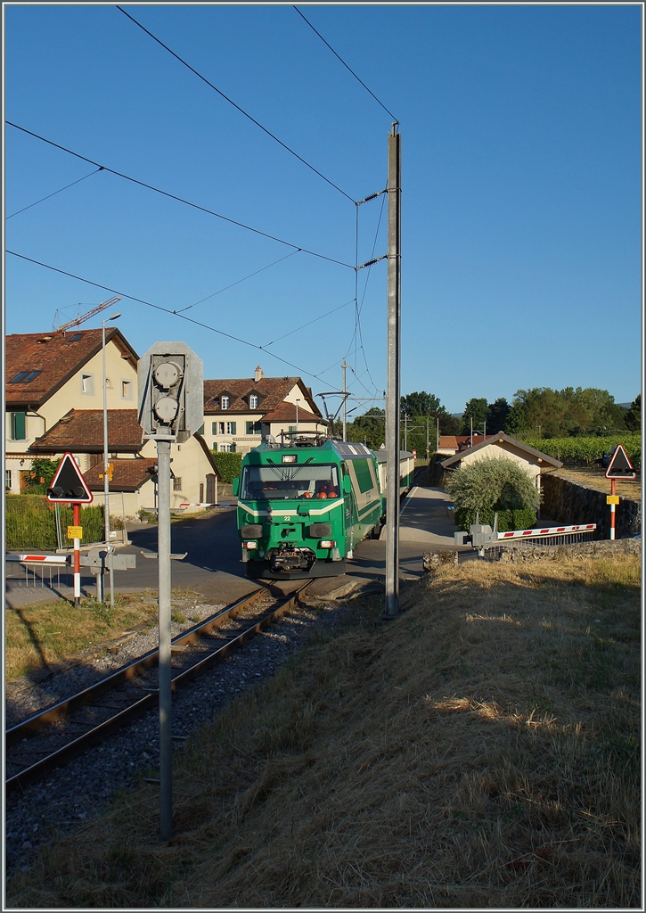 Der von der Ge 4/4 22 gezogen Zug BAM 105 in Vufflens le Château. Einen Monat nach dem höchsten Sonnenstand machten sich unvermutet bereits erste Schatten bemerkbar. 
21. Juli 2015
