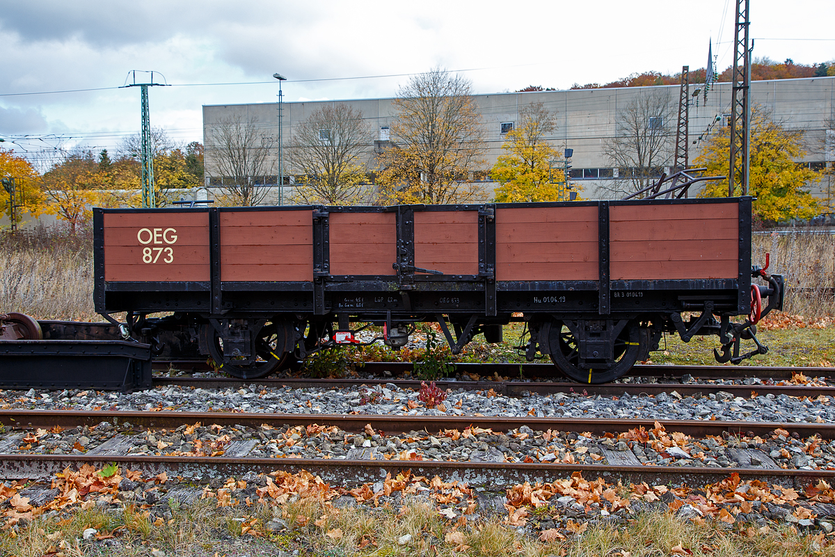 Der schmalspurige zweiachsige offene Güterwagen Ow 873 bei einer der beiden Rollbockgrube (Umspuranlage) der meterspurigen Museumsbahn Alp-Bähnle Amstetten-Oppingen (ex WEG Württembergische Eisenbahn Gesellschaft, Bahnstrecke Amstetten- Oppingen-Laichingen) am 26.10.2021 beim Bahnhof Amstetten.

Der Ow 873 wurde im Jahr 1899 von der Firma Horney & Rödler in Neustadt i. Mecklenburg für die Süddeutsche Eisenbahn Gesellschaft gebaut. Er wurde der Bahn Mannheim-Weinheim-Heidelberg zugeordnet, die 1912 in der Oberrheinischen Eisenbahn Gesellschaft (OEG) aufging. Ab den 1970er Jahren diente der Wagen der Bahnmeisterei und erhielt einen orangenen Anstrich mit Warnbaken.

Die Ulmer Eisenbahnfreunde konnten den Wagen 1988 fürs Alb-Bähnle übernehmen. Als Vertreter des wohl bei Schmalspurbahnen damals am häufigsten anzutreffenden offenen Güterwagens dient er heute zum Transport von Fahrrädern oder zur Darstellung des Gütertransports zu besonderen Anlässen.

TECHNISCHE DATEN:
Spurweite: 1.000 mm (Meterspur)
Anzahl der Achsen: 2
Länge über Puffer: 6.200 mm
Eigengewicht: 4,5 t
Handbremse: Ja