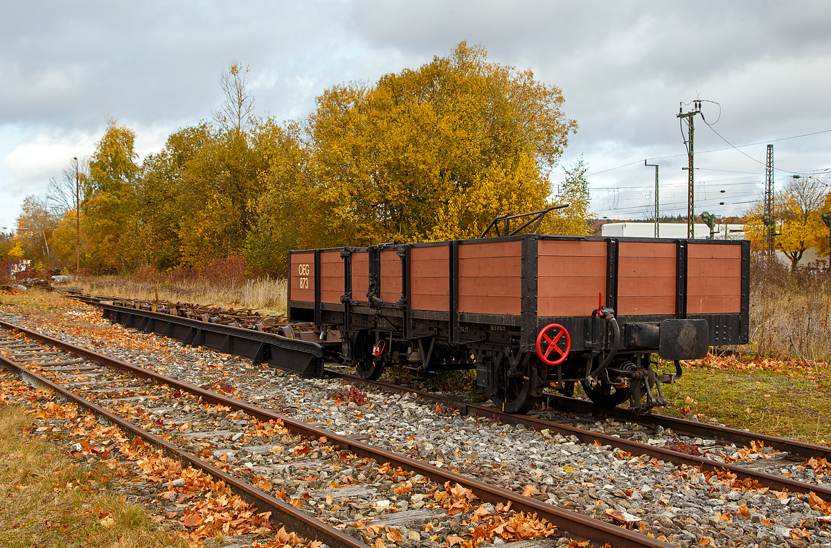 Der schmalspurige zweiachsige offene Güterwagen Ow 873 bei einer der beiden Rollbockgrube (Umspuranlage) der meterspurigen Museumsbahn Alp-Bähnle Amstetten-Oppingen (ex WEG Württembergische Eisenbahn Gesellschaft, Bahnstrecke Amstetten- Oppingen-Laichingen) am 26.10.2021 beim Bahnhof Amstetten.

Der Ow 873 wurde im Jahr 1899 von der Firma Horney & Rödler in Neustadt i. Mecklenburg für die Süddeutsche Eisenbahn Gesellschaft gebaut. Er wurde der Bahn Mannheim-Weinheim-Heidelberg zugeordnet, die 1912 in der Oberrheinischen Eisenbahn Gesellschaft (OEG) aufging. Ab den 1970er Jahren diente der Wagen der Bahnmeisterei und erhielt einen orangenen Anstrich mit Warnbaken.

Die Ulmer Eisenbahnfreunde konnten den Wagen 1988 fürs Alb-Bähnle übernehmen. Als Vertreter des wohl bei Schmalspurbahnen damals am häufigsten anzutreffenden offenen Güterwagens dient er heute zum Transport von Fahrrädern oder zur Darstellung des Gütertransports zu besonderen Anlässen.

TECHNISCHE DATEN:
Spurweite: 1.000 mm (Meterspur)
Anzahl der Achsen: 2
Länge über Puffer: 6.200 mm
Eigengewicht: 4,5 t
Handbremse: Ja
