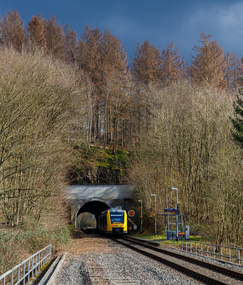 
Der VT 504 (95 80 1648 104-5 D-HEB / 95 80 1648 604-4 D-HEB) ein Alstom Coradia LINT 41 der neuen Generation der HLB (Hessische Landesbahn GmbH), fährt als  RB 96  Hellertalbahn  (Betzdorf/Sieg - Herdorf - Neunkirchen) am 07.03.2020 durch den Hp Herdorf-Königsstollen (Bedarfshaltestelle), gleichdarauf geht es durch den 137 m langen Herdorfer Tunnel. 

Rechts das dreibegriffige Einfahrvorsignal (für den Bf Herdorf) steht auf Signal Vr 2 – Langsamfahrt erwarten (Die Runde orange Scheibe mit schwarzem Ring und weißem Rand steht senkrecht, der Flügel, mit gleicher Farbanordnung wie die Scheibe, zeigt mit der Spitze nach rechts abwärts. Rechts daneben die Vorsignaltafel (Signal Ne 2). So wird der Standort desVorsignales eindeutig gekennzeichnet.