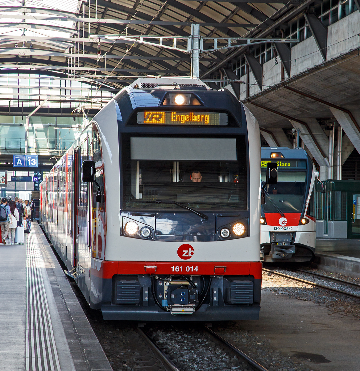Der zb Abeh 161 014  Sarnen , ein 3-teiliger elektrischer Zahnradtriebzug vom Typ Stadler FINK (Flinke, innovative Niederflur-Komposition) der ZENTRALBAHN am 25.09.2016 als IR nach Engelberg im Bahnhof Luzern.

Die Zentralbahn hatte Mitte September 2009 bei Stadler Rail vier siebenteilige elektrische Zahnrad- und Adh�sionstriebz�ge ABeh 150 „ADLER“  sowie sechs dreiteilige elektrische Zahnrad- und Adh�sionstriebz�ge ABeh 160 „FINK“ bestellt. 2014 wurden f�nf weitere FINK bestellt, die neue Serie wird als ABeh 161 bezeichnet. Die neuen Triebz�ge unterscheiden sich nur unwesentlich von der ersten Serie der Fink-Zahnradz�ge. Verbesserungen gibt es etwa bei den Zahnraddrehgestellen, um den vorzeitigen Verschlei� zu vermindern und die Lebensdauer zu erh�hen. Neu werden die R�der etwas gr��er und mit Bandagen ausgef�hrt.

Die dreiteiligen Pendelz�ge bieten auf 54 Metern L�nge 139 Sitzpl�tze, davon 18 in der ersten Klasse. Das Gewicht der Z�ge betr�gt ca. 92 Tonnen, die H�chstgeschwindigkeit 120 km/h. Sie sind mit den siebenteiligen ZB ABeh 150 kuppel- und vielfachsteuerbar. Zwei von drei Einstiegen pro Seite sind im Niederflurbereich angelegt. Im Unterschied zu den ABe 130 haben auch die Mittelwagen Einstiegst�ren. Die Wagen sind klimatisiert. Sie verf�gen �ber gro�e Panoramafenster, es gibt Fahrrad- und Skihalter und Rollstuhlpl�tze. Der Adh�sions- und Zahnradantrieb sind r�umlich getrennt, mechanisch entkoppelt und damit schlupffrei. Die Enddrehgestelle sind die Adh�sionstriebdrehgestelle, die Adh�sionsantriebe laufen auch auf den Zahnstangenabschnitten mit und erbringen dort etwa ein Drittel der Antriebsleistung. Der mittlere Wagenkasten l�uft auf den Zahnradtriebdrehgestellen mit je zwei Laufachsen. Die jeweils inneren tragen den Zahnradantrieb.

Bei den ADLER und FINK kommt ein neu entwickelter Zahnradantrieb mit exzentrischer H�henverstellung zum Einsatz, der konstruktiv einem �blichen Zahnradantrieb mit Tatzlagerung entspricht, wie er von reinen Zahnradfahrzeugen bekannt ist. Die Trieb- beziehungsweise Bremszahnr�der st�tzen sich nicht direkt auf der Radsatzwelle, sondern auf einer zus�tzlich eingef�gten, nicht umlaufenden Hohlwelle ab, die mit der Radsatzwelle �ber Exzenterscheiben verbunden sind.Durch Drehen der Exzenterscheiben l�sst sich der Zahneingriff auf einfache Weise dem Radverschlei� entsprechend in sieben Stufen von je 5 mm anpassen, wodurch ein Radverschlei� von 35 mm statt 12 mm m�glich ist.

Die Wagenk�sten und der Adh�sionsantrieb der ABeh 160 und ABeh 150 dienten als Vorbild f�r die Westschweizer Meterspurz�ge von Stadler. Auch bei der Konstruktion der ABDeh 8/8 der Berner Oberland-Bahnen wurde die Kastenstruktur und zahlreiche weitere Komponenten von Fink und Adler �bernommen.

TECHNISCHE DATEN:
Bezeichnung: ABeh 160 / ABeh 161
Einsatzbahn : Zentralbahn (zb)
Einsatzgebiet: Luzern – Interlaken Ost; Luzern – Engelberg S-Bahn
Spurweite: 1.000 mm
Zahnradsystem: 	Riggenbach
Achsanordnung: B0’1Az’Az1’B0’
Anzahl Fahrzeuge: 11
Baujahre: 2012 / 2016
L�nge �ber Kupplung: 54.000 mm
Fahrzeugbreite: 2.650 mm
Fahrzeugh�he 4.050 mm ab SOK
Achsabstand im Adh�sionstriebdrehgestell: 2.000 mm
Achsabstand im Lauf-/Zahnradtriebdrehgestell: 2.380 mm
Raddurchmesser: 810 mm (neu) / 740 mm (abgen�tzt)
Dienstgewicht, tara: ca. 92 t
Sitzpl�tze: 147
Davon Klappsitze: 8
Fu�bodenh�he Niederflur: 420 mm
Fu�bodenh�he Hochflur: 1.100 mm
Einstiegbreite: 1.300 mm
Fahrmotor Drehstrom: TMF42-38-4
Max. Leistung: 1.400 kW (Adh.) / 1.600 kW (Zahnr.)
Anfahrzugkraft Adh�sion: 120 kN
Anfahrzugkraft Zahnradstrecke: 220 kN
H�chstgeschwindigkeit Adh�sion: 120 km/h
H�chstgeschwindigkeit Zahnstange: 40 km/h bergw�rts / 29.0 km/h (105 ‰) talw�rts / 27.5 km/h (120 ‰) talw�rts
Maximale Steigung Zahnrad:120 ‰
Maximale Steigung Adh�sion:  35 ‰
