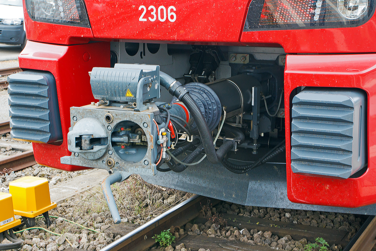 
Detail Scharfenbergkupplung (Schaku) Typ 10 mit obenliegender Elektrokontaktkupplung. Hier auch gut zu sehen die Anlenkung mit Stoßsicherung und der Zug- und Stoßeinrichtung. Hersteller der kompletten Einheit ist Voith Turbo Scharfenberg GmbH & Co. KG in Salzgitter
Hier an CFL 2306, ein dreiteiliger Elektrischer Doppelstocktriebzug Stadler KISS, am 14.09.2014 im Bahnhof Wasserbillig.
