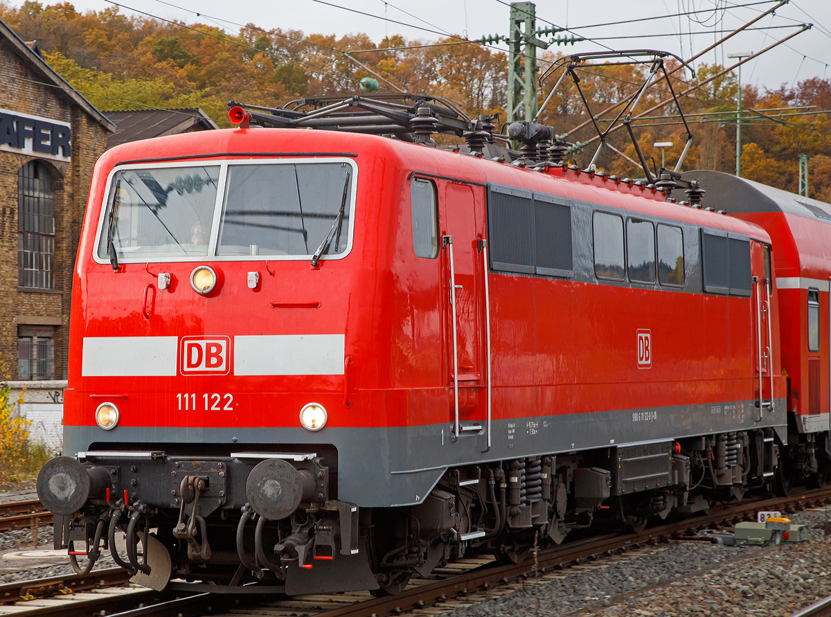 Die 111 122-8 (91 80 6111 122-8 D-DB) der DB Regio NRW fährt am 07.11.2015, mit dem RE 9  rsx / Rhein-Sieg-Express  (Aachen-Köln-Siegen), in den Bahnhof Betzdorf/Sieg ein. 

Die Lok wurde 1980 von Krauss-Maffei in München unter der Fabriknummer  19854 gebaut, der elektrische Teil wurde von Siemens geliefert.

Von den Loks der Baureihe 111 wurden zwischen 1974 bis 1984 insgesamt 227 Stück von verschiedenen Herstellern (AEG, BBC, Henschel, Krauss-Maffei, Krupp, Siemens) gebaut, 222 Stück sind noch im Bestand der DB. Die Baureihe 111 ist die Nachfolgerin der Schnellzuglok-Baureihe 110, an deren Konstruktion sie sich auch stark anlehnt.  Besonderes Augenmerk legte man dabei auf die Verbesserung der Laufruhe bei hohen Geschwindigkeiten durch neue Drehgestelle und verbesserte Arbeitsbedingungen für den Lokführer.

Auf dem Dach waren die neuen Einholm-Stromabnehmer Bauart SBS 65 vorgesehen, welche jedoch bei den Maschinen der ersten bis dritten Serie (111 001–146) nur zum Teil verwendet wurden und kurz darauf wieder abgebaut und gegen Scherenstromabnehmer der Bauart DBS 54 ausgetauscht wurden, da die Einholmstromabnehmer für die Baureihe 103 benötigt wurden. Deshalb fahren Loks der ersten Serien teilweise bis heute mit Scheren-Stromabnehmern DBS 54a, wie hier die gezeigte 111 122-8.

Eingesetzt werden die 160 km/h schnellen Lokomotiven heute vorwiegend im Regional- und Nahverkehr, während bei der Indienststellung auch der leichte Personen-Fernverkehr zu ihrem Aufgabengebiet gehörte.


Technische Daten:
Spurweite: 1.435 mm
Achsformel: Bo'Bo'
Länge über Puffer: 16.750 mm. 
Fahrmotoren: 4 Stück  á 905 kW = 3.620 kW Leistung, 
Dienstgewicht: 83 t 
Anfahrzugkraft: 274 kN
Höchstgeschwindigkeit: 160 km/h