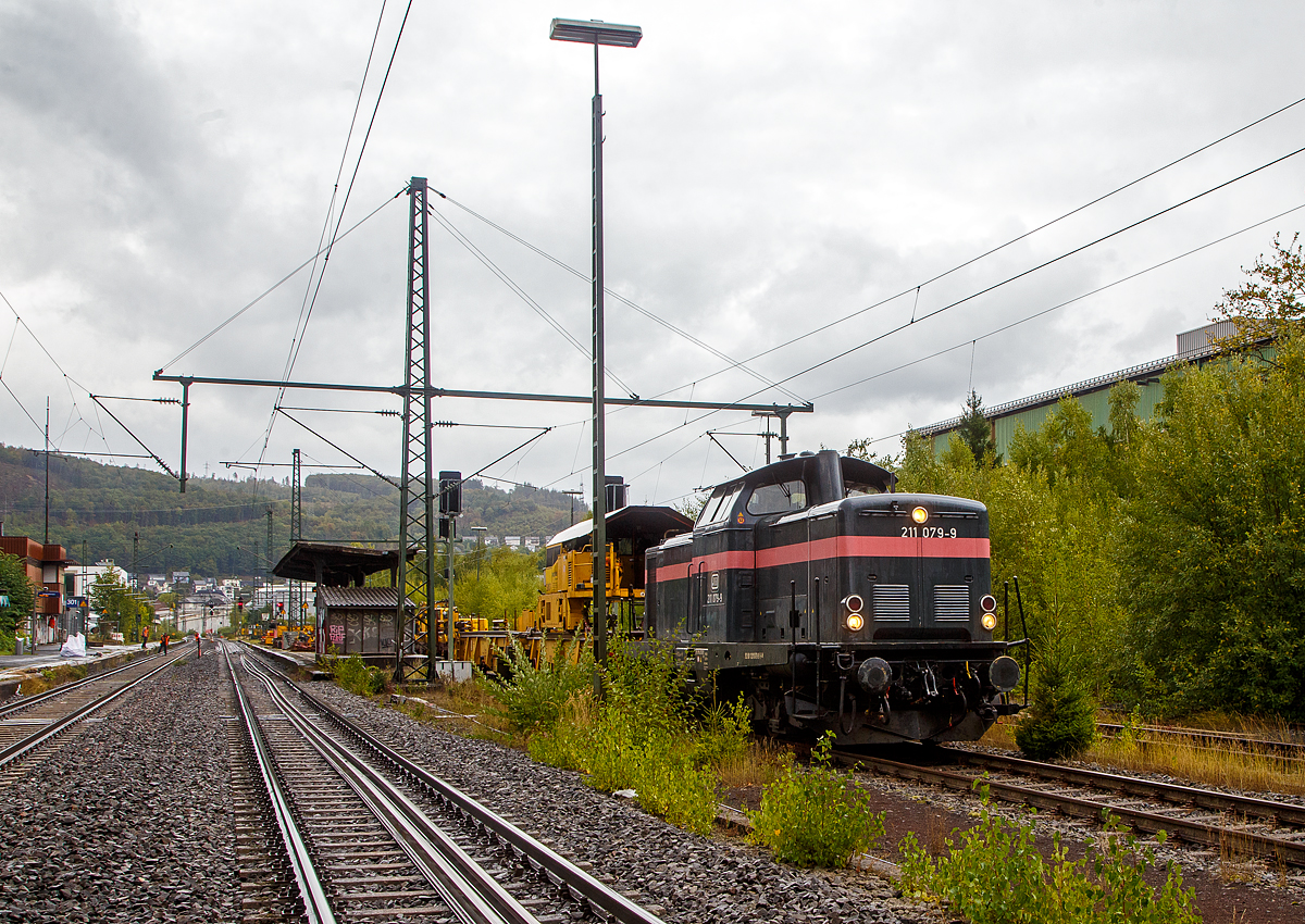 Die 211 079-9 (92 80 1211 079-9 D-JH) der JH - Joseph Hubert Bauunternehmung GmbH & Co. KG (Nürnberg), ex DB V 100 1079, am 17.09.2022 mit einem Schienenzug (Vossloh Langschienentransporteinheit STS und Schienen-Ladewagen SLW 7) beim Bahnhof Niederschelden (geografisch eigentlich Niederschelderhütte). Gleisbereich ja, aber im Gleis wurde gearbeitet und ich wurde aufgefordert das ich hier ein bild machen sollt.

Die V 100.10 wurde 1962 von MaK (Maschinenbau Kiel) unter der Fabriknummer 1000097 gebaut und als V 100 1079 an die Deutsche Bundesbahn geliefert. Zum 01.01.1968 erfolgte dann die Umzeichnung in DB 211 079-9, als diese fuhr sie bis zur Ausmusterung 1995. Im Jahr 2000 ging sie an die HEF - Hammer Eisenbahnfreunde e. V., 2015 an Redler-Service (92 80 1211 079-9 D-RAILS), in Jahr 2019 ging sie dann an die jh - Joseph Hubert Bauunternehmung.

Auf der Siegstrecke (KBS 460) erfolgen zwischen dem 16.09. bis zum 09.12.2022 in verschiedenen Anschnitten und Zeiträumen umfangreiche Umbauarbeiten. Hier zwischen Siegen und Betzdorf zwischen dem 16.09. bis zum 05.10.2022. Die DB Netz AG investiert über 12 Millionen Euro in moderne Infrastruktur.

Die V100.10  (BR 211) haben eine12-Zylinder-Viertakt-Dieselmotor mit etwas geringerer Leistung gegenüber der V 100.20. Da die V 100.10 (BR 211) für den leichten Reise- und Güterzugdienst auf Nebenstrecken vorgesehen war. Bei den V 100.10 kam überwiegend der Maybach MD 650 1B und der Daimler-Benz MB 820 Bb zum Einsatz, seltener war der MAN L 12 V 18/21 zu finden. Die Nennleistung lag bei 809 kW (1100 PS).

TECHNISCHE DATEN:
Spurweite: 1.435 mm
Achsfolge: B'B'
Eigengewicht: 63,0 t
Länge über Puffer: 12.300 mm
Drehzapfenabstand: 6.000 mm
Achsstand im Drehgestell: 2.200 mm
größte Breite: 3.115 mm
größte Höhe über Schienenoberkante: 4.275 mm
kleinster befahrbarer Gleisbogen: 100 m
Treibraddurchmesser: 950 mm
Höchstgeschwindigkeit: 100 km/h
Antrieb: dieselhydraulisch
Leistung:	809 kW (1.100 PS)
Nenndrehzahl: 1.500 U/min
Anfahrzugkraft: 177 kN
Kraftübertragung: hydraulisch
Kupplungsart: Schraubenkupplung
