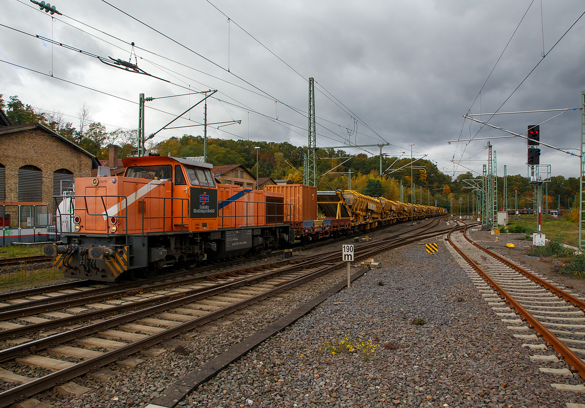 Die an die BEG - Bocholter Eisenbahngesellschaft mbH vermietete 275 103-0 (92 80 1275 103-0 D-NRAIL) eine Vossloh G 1206 der Northrail fährt am 22.10.2021 mit einem langen Bauzug der MGW Gleis- und Weichenbau-GmbH & Co. KG (Berlin) durch Betzdorf (Sieg) in Richtung Siegen. Der Bauzug bestand aus acht Plasser & Theurer Materialförder- und Siloeinheit MFS 100, der Plasser & Theurer Bettungsreinigungsmaschine RM 95-700, sowie zwei Schutzwagen.

Die G 1206 wurde 2001 von Vossloh unter der Fabriknummer 1001139 gebaut und war erst als Vossloh Mietlok im Einsatz. Im Jahr 2006 ging sie an die Mittelweserbahn GmbH in Bruchhausen-Vilsen als MWB V 2103 (ab 2007 NVR-Nummer: 92 80 1275 103-0 D-MWB). 2013 wurde sie an die Vermietungsfirma Northrail GmbH in Hamburg verkauft. 

TECHNISCHE DATEN der G 1206:
Spurweite: 1.435 mm
Antriebart:  dieselhydraulisch
Achsfolge: B'B' 
Länge über Puffer: 14.700 mm
Drehzapfenabstand: 7.200 mm
Achsabstand im Drehgestell: 2.400 mm
größte Breite: 3.080 mm
Höhe über Schienenoberkante: 4.220 mm
Raddurchmesser neu: 1.000 mm
Motor: Caterpillar 12 Zylinder 4-Takt Dieselmotor mit Abgasturbolader und Ladeluftkühlung vom Typ 3512B DITA-SC
Leistung: 1.500 kW bei1.800 U/min
Strömungsgetriebe: Voith L5r4zU2 
Anfahrzugkraft: 282 kN
Höchstgeschwindigkeit 100 km/h
max. Schleppgeschwindigkeit : 80 km/h
kleinste Dauerfahrgeschwindigkeit: 10 km/h
kleinster befahrbarer Gleisbogen: 60 m
Dienstgewicht: 87,3 t
Kraftstoffvorrat: 3.150 l
Zulassungen: DE, NL, FR, CH