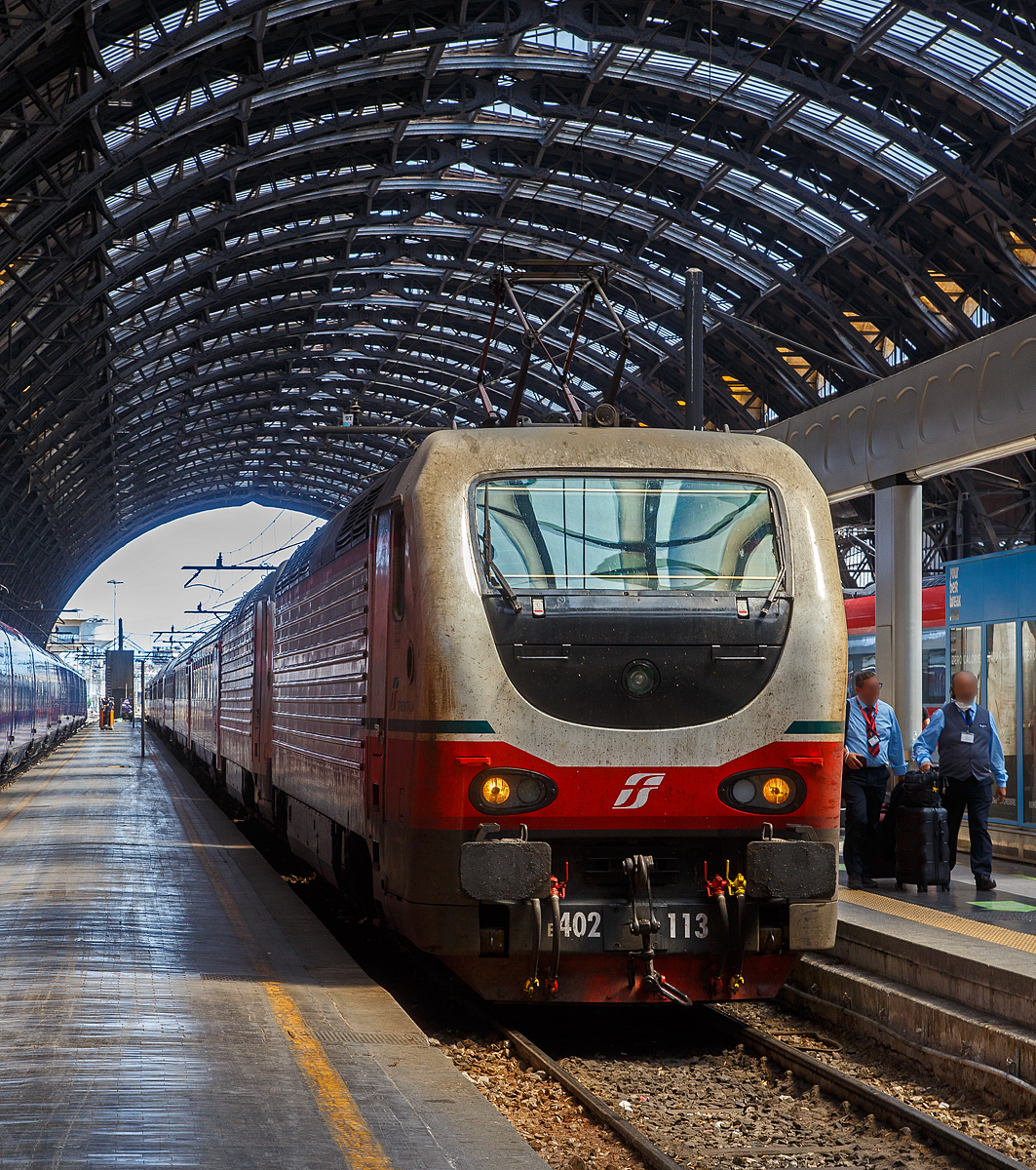 Die beiden E.402B 113 und 111 (91 83 2402 113-x I-TI und 91 83 2402 111-5 I-TI) erreichen am 12.07.2022, mit einem Trenitalia InterCity Notte (ICN), den Bahnhof Milano Centrale (Mailand Hbf).

Die FS E.402B ist eine Weiterentwicklung der E.402A, verfügt jedoch gegenüber ihrem Vorgängermodell zum Beispiel über ein höheres Gewicht sowie einen neu gestalteten und futuristischeren Wagenkasten. Die Höchstgeschwindigkeit ist jedoch mit 200 km/h etwas geringer als bei der E.402A (mit 220 km/h). Von den Loks wurden 80 Stück zwischen 1997 und 2000 von Ansaldo, Firema Trasporti (Fiore-Casertane), ITIN und SOFER gebaut.

Die Baureihe E.402B ist eine Mehrstromlokomotive, sie kann unter 3.000 V Gleichstromspannung, dem hauptsächlichen italienischen Bahnnetz, aber auch auf den italienischen Schnellfahrstrecken mit 25 kV, 50 Hz Wechselstrom fahren. Fernerhin kann sie unter 1.500 V Gleichstrom betrieben werden, dann hat sie aber nur die halbe Leistung. 

Die Lok ist eine vollelektronische Chopperlokomotive, das heißt, wenn die Lokomotiven unter 3.000 V DC fährt, wird der Strom mit Hilfe eines Zerhackers in Wechselstrom umändern, der dann schließlich die Motoren antreibt. 

TECHNISCHE DATEN:
Spurweite:  1435 mm (Normalspur)
Achsformel: Bo'Bo'
Länge: 19.420 mm
Drehzapfenabstand: 10.450 mm
Achsabstand im Drehgestell: 2.850 mm
Treibraddurchmesser:  1.250 mm
Dienstgewicht: 89 t
Höchstgeschwindigkeit: 200 km/h
Stundenleistung: 6.000 kW
Dauerleistung: 5.600 kW
Anfahrzugkraft: 280 kN
Stromsysteme: 3000 V DC, 25 kV - 50 Hz AC und 1500 V DC (bei halber Leistung)
