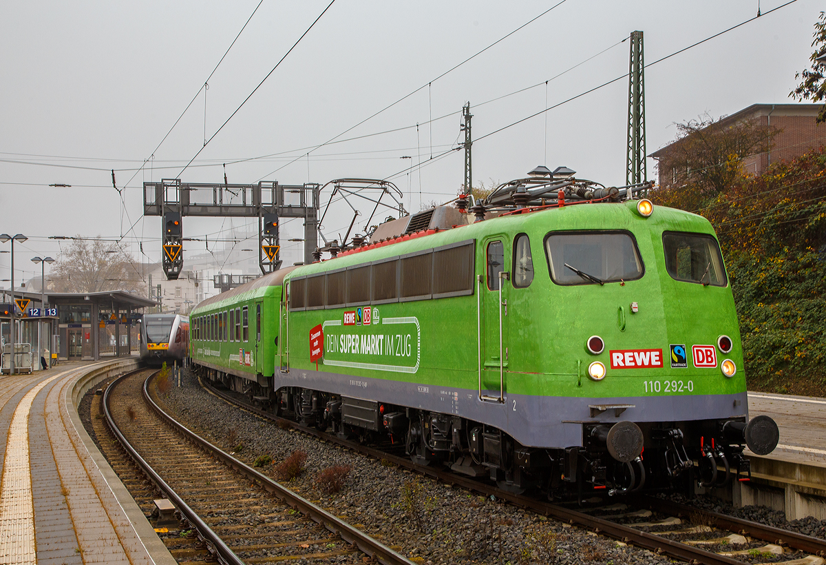 Die B�gelfalten E 10  die 110 292–0 (91 80 6110 292-0 D-GfF) der Gesellschaft f�r Fahrzeugtechnik mbH (bzw. Gesellschaft f�r Eisenbahnbetrieb) steht am 12. und 13.11.2021 (hier 12.11.) mit dem REWE - Supermarkt-Zug im Bahnhof Gie�en.

In Hessen ein zu einem Supermarkt umgebauter Zug in Betrieb genommen worden. Wie die Deutsche Bahn-Tochter DB Regio, der Nahversorger Rewe Region Mitte und der Verein Fairtrade Deutschland mitteilten, werden in dem �Fairen Supermarktzug� k�nftig regionale, �kologische und fair gehandelte Produkte angeboten. Der aus drei Einkaufswaggons, einem Dienstwagen und einem Bord-Bistro bestehende Zug steht an den folgenden Wochenenden (freitags und samstags von 9.00 bis 19.00 Uhr) in den Bahnh�fen Fulda, Kassel, Darmstadt und Wiesbaden. Den �Supermarktzug� f�hren Rewe-Auszubildende.

In Hessen hat Rewe zusammen mit DB Regio eine geniale Idee verwirklicht: Kunden k�nnen hier in einer ganz besonderen Filiale einkaufen. Sie befindet sich im Bahnhof – nicht im Foodcorner, sondern auf der Schiene.

Ach so die Lok hat schon �ber 57 Jahr auf dem Buckel, sie wurde 1964 von Krauss-Maffei in M�nchen-Allach unter der Fabriknummer 18770 gebaut, die Elektrik ist von SSW (Siemens-Schuckertwerke). Sie wurde als E10 292 an die Deutsche Bundesbahn geliefert. Mit der Einf�hrung des EDV-Nummernsystems wurde sie zum 01.01.1968 zur DB 110 292-0, im Jahr 2010 ding sie ins DB-Museum Koblenz-L�tzel, zum 01.01.2021 wurde sie an die GfE Gesellschaft f�r Eisenbahnbetrieb mbH in Crailsheim verkauft.
