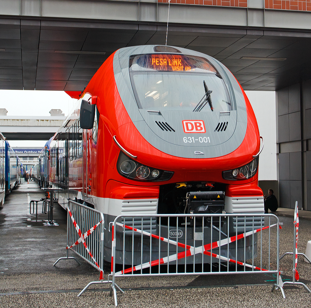 
Die Deutsche Bahn AG und der polnischer Hersteller PESA stellen ersten Dieseltriebzug LINK für die DB vor. Hier das Vorserienfahrzeug 631-001 (95 80 0631 001-4 D-DB ABpd) ausgestellt am 26.09.2014 auf der InnoTrans 2014 in Berlin.

Der PESA LINK (Projektname DMU 120) ist ein Dieseltriebwagen des polnischen Herstellers PESA (Pojazdy Szynowe PESA Bydgoszcz Spolka Akcyjna). Die ČD (Tschechische Bahnen) vermarkten sie als „RegioShark“ (RegioHai), Hai war auch mein erster Eindruck. Es werden verschiedene Varianten von ein- bis vierteiligen Triebzügen angeboten. Diese einteilige Variante ist als Baureihe 631 eingereiht, von denen die DB nur ein Fahrzeug zur Erprobung und zur späteren Reserve bestellt hat. Ansonsten har die Deutsche Bahn AG zurzeit 22 Zweiteiler (BR 632) und 49 Dreiteiler (BR 633) bestellt. Ab Dezember 2015 sollen die ersten planmäßig auf dem Sauerland-Netz (als RB 52 bis 54 und RE 57) fahren.

Der einteilige PESA Link der BR 631 hat einem Dieselmotor (MTU PowerPack) mit einer Leistung von 565 kW, welcher beide Achsen eines Drehgestelles antreibt. Der Motor erfüllt die Stage-IIIb-Abgasnorm und beschleunigt den Triebwagen auf bis zu 140 km/h. Der PESA Link erlaubt Mehrfachtraktionen von drei Treibzügen.

Der Innenraum des Pesa Link ist im Mittelteil in Niederflurbauweise ausgeführt, während die Fahrgastbereiche an den Fahrzeugenden hochflurig ausgelegt sind. Die Bodenhöhe des Niederflurbereichs beträgt in der DB-Version 760 mm, um einen niveaugleichen Übergang von Bahnsteig zu Fahrzeug zu gewährleisten. Jedes Fahrzeug verfügt über ein Mehrzweckabteil Rollstuhlrampen für ältere Bahnsteige von geringerer Höhe und eine behindertengerechte Toilette. In den Fahrzeugen sind Monitore installiert, auf denen sich der weitere Fahrtverlauf nachvollziehen lässt. Die Fahrzeuge der Deutschen Bahn im Sauerland-Netz werden überdies mit einem Fahrkartenautomaten und Steckdosen für die Fahrgäste ausgestattet sein.

Technische Daten der BR 631:
Spurweite: 1.435 mm (Normalspur)
Achsformel: B'2'
Länge über Puffer:  28,65 m
Höhe: 4.280 mm
Breite: 2.880 mm
Achsabstand im Drehgestell: 2.100 mm
Kleinster bef. Halbmesser: 100 m (Werkstatt) / 150 m (Betrieb)
Höchstgeschwindigkeit: 140 km/h
Installierte Leistung: 565 kW 
Beschleunigung:  0,74 m/s²  0-30 km/h
Antrieb: MTU Powerpack
Kupplungstyp: 	Scharfenberg
Sitzplätze: 50
