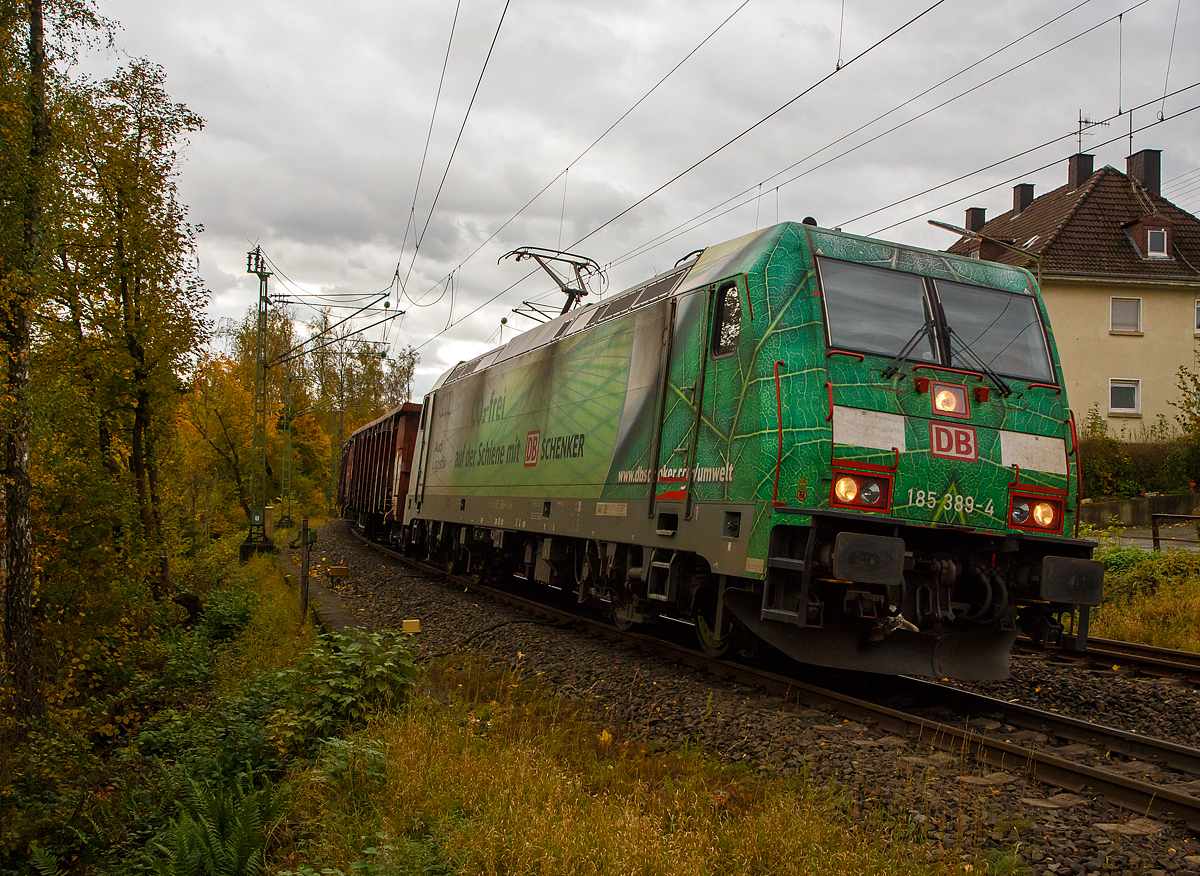 Die grüne DB Cargo 185 389-4 (91 80 6185 389-4 D-DB), mit Werbung „DB Schenker/Audi Logistik Co2-frei“, fährt am 22.10.2021 mit einem offenen Güterzug (Wagen der Gattung Eaos-x) durch Kirchen (Sieg) in Richtung Siegen. Hinweis: Ich stehe beim BÜ km 121,192.

Die TRAXX F140 AC2 wurde 2009 von Bombardier in Kassel unter der Fabriknummer 34693 gebaut. Sie hat die Zulassungen für Deutschland und Österreich.
