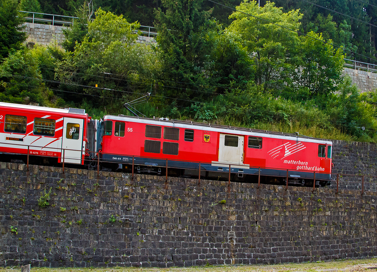 
Die MGB Deh 4/4 – 55 „Brig“ erreicht mit einem Schöllenenbahnzug von Andermatt am 01.08.2019 Göschenen.

Der Gepäcktriebwagen wurde 1972 gebaut, der Lokomotivkasten ist von SIG, die Triebdrehgestelle von SLM und die elektrische Ausrüstung von BBC.

Da das Rollmaterial in den 60er Jahren großenteils veraltet und der Verkehr in der Wintersaison stark angestiegen war, benötigte die FO dringend leistungsfähigere Triebfahrzeuge. Man entschied sich für leistungsfähige Gepäcktriebwagen, die freizügig auf dem gesamten Netz eingesetzt werden konnten. Die fünf Fahrzeuge des Typs Deh 4/4 wurden 1972 bestellt und lösten die HGe 2/2 und die ABDeh 2/4 ab, die den Wintersportverkehr auf der Schöllenenbahn nicht mehr bewältigen konnten. 

Ein Nachbau der FO-Deh 4/4 erhielt einen völlig andersartigen Kasten, weshalb diese Fahrzeuge bei der FO als Deh 4/4 I und II unterschieden wurden. Seit der Fusion zur MGB ist diese Bezeichnung nicht mehr gebräuchlich, die MGB unterscheidet die Serien nach den Nummernbereichen 21, 51 und 91. Wobei sie sich schon optisch und auch technisch etwas unterscheiden.

Technische Daten Deh4/4 I (51-55):
Spurweite: 1.000 mm
Achsformel: Bo'zz Bo'zz
Länge über Puffer: 16.900 mm
Größte Breite: 2.650 mm
Größte Höhe (bei abgesenkten Stromabnehmer): 3.880 mm
Leergewicht: 48,3  t 
Dienstgewicht: 50,3 t
Maximale Zuladung: 2,0 t
Höchstgeschwindigkeit: Adhäsion 60 km/h / Zahnstange 30 km/h
Stundenleistung: 1.032 kW
Dauerleistung: 936 kW
Treibraddurchmesser:  790 mm (Adhäsion) / 688 mm (Zahnrad)
Stromsystem: 11 kV 16,7 Hz AC
Anzahl der Fahrmotoren: 4
Größe der Ladefläche: 11,5 m²