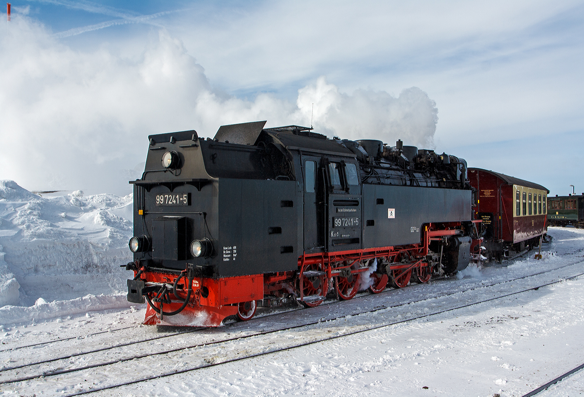 Die Neubau-Dampfloks der HSB - Harzer Schmalspurbahnen 99 7241-5 (ex DR 099 151-3, 99 0241-2, 99 241) stehen am 23.03.2013 auf dem Bahnhof Brocken (1.125 m ü.NN) zu Talfahrt bereit. 

Den mächtigen See sieht man ja, aber nicht die Minus 17 Grad Kälte und bei dem starken Wind waren es gefühlte 30 Grad Minus. Links oben sieht man die Spitze vom Brockenturm.

Die Meterspurige Dampflok wurde 1956 bei LKM (VEB Lokomotivbau Karl Marx Babelsberg unter der Fabriknummer 134018 gebaut und als DR 99 241 an die Deutsche Reichsbahn geliefert. Zum 01.07.1970 erfolgte die Umzeichnung in DR 99 7241-5, nachdem man sie 1979 auf Ölfeuerung umbaute wurde sie als DR 99 0241-2 bezeichnet. Da die Ölfeuerung nicht zum Vorteil der Maschinen war und Öl in der DDR knapp war wurde sie (wie alle Loks) 1983 wieder auf Kohlefeuerung zurück gebaut und nun wieder als DR 99 7241-5 bezeichnet. Ab dem 01.01.1992 wurden die Lok noch als DR 099 151-3 um bezeichnet, bis am 01.02.1993 in die HSB überging, welche dann wieder die alte DR-Bezeichnungen verwendete.

Diese Neubau-Dampfloks der  Bauart 1'E1' h2t / Gattung K 57.10 werden als Baureihe 99.23–24 geführt (und nicht fälschlicherweise als 99.72, diese hätte eine Spurweite von 750 mm).  Wie man an der Bauart und Gattung sehen kann haben sie 7 Achsen, 5 davon sind angetrieben und je eine Laufachse befindet sich vor und hinter den Triebachsen.  Die Radsatzfahrmasse beträgt 9,5 t.

Weitere Technische Daten:
Spurweite: 1.000 mm (Meterspur) 
Länge über Puffer: 12.500 mm
Höhe:  3.650 mm
Breite:  2.645 mm
Fester Radstand:  4.800 mm
Gesamtradstand:  8.700 mm (1.950 / 4x1.200 / 1.950)
Kesselüberdruck : 14 bar
Leistung: 515 kW (700 PS)
Höchstgeschwindigkeit: 40 km/h (Vor- und Rückwärts)
Eigengewicht: 47.5 t
Dienstgewicht: 64,5 t (bei vollen Vorräten)
Kohlevorrat: 4,0 t
Wasservorrat: 8 m³
Anfahrzugkraft:  102,9 kN (10,5 Mp)
Treibraddurchmesser:  1000 mm
Laufraddurchmesser:  550 mm
