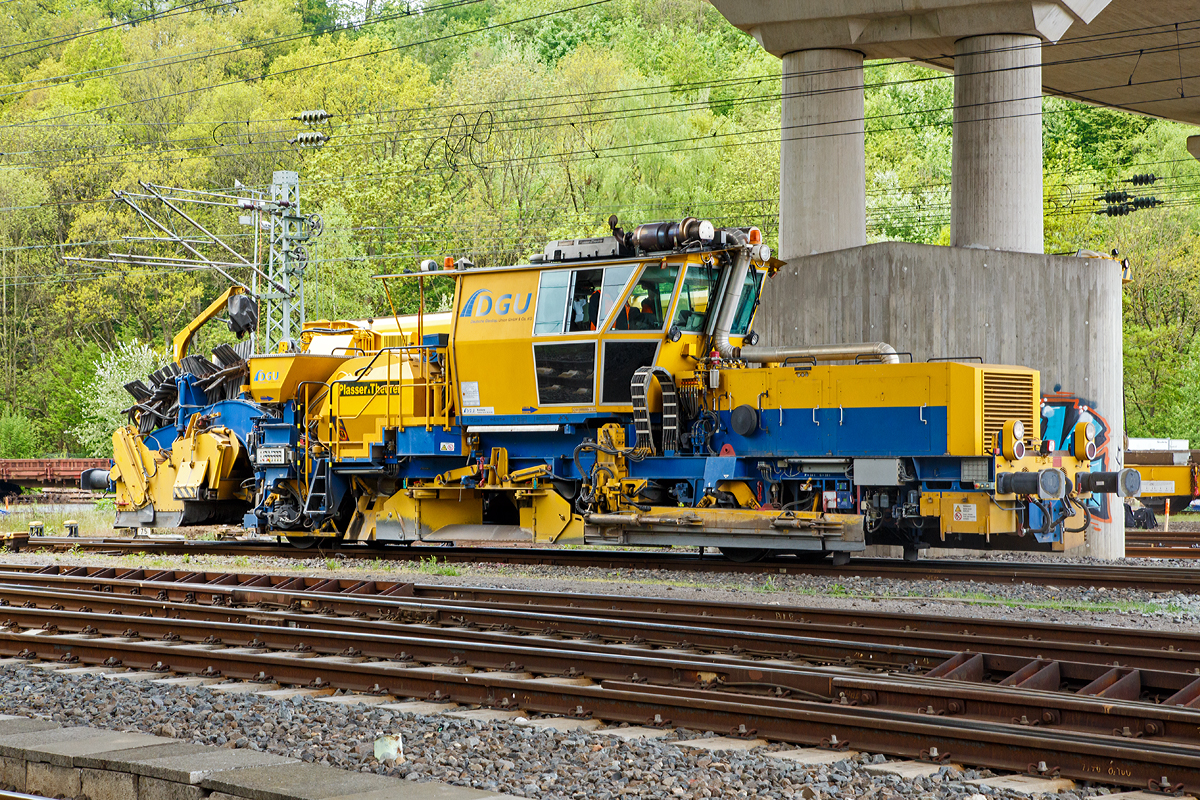 
Die Plasser & Theurer Schnellschotterplaniermaschine SSP 110 SW (Schweres Nebenfahrzeug Nr. 97 16 46 516 18-9; EBA 04 B09 B017) der DGU - Deutsche Gleisbau Union (Koblenz), am 09.05.2015 im Einsatz beim Hbf Siegen, hier wurden Weichen erneuert. 

TECHNISCHE DATEN der SSP 110 SW:
Spurweite: 1.435 mm
Eigengewicht: 44 t
zul. Anhängelast: 40 t
Länge über Puffer: 17.230 mm
Achsabstand: 8.100 mm
Achsanzahl: 2 (große Räder)
Motorleistung: 400 kW
Höchstgeschwindigkeit: 100 km/h
Kleinster befahrbarer Radius: 120 m
zul. Streckenklasse: D4 oder höher
Zur Mitfahrt zugel. Personen: 3