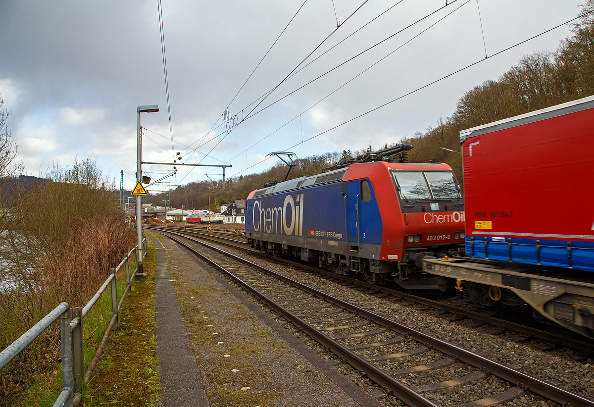 Die Re 482 012-2 „ChemOil“ (91 85 4482 012-2 CH-SBBC) der SBB Cargo AG fährt am 09.04.2022, mit einem „Winner“-KLV -Zug durch Scheuerfeld (Sieg) in Richtung Siegen. Links im Bild kann man die Sieg (Fluss) erkennen, die der Strecke (Siegstrecke) den Namen gibt und oft auf der Fahrt zwischen Siegburg und Siegen überquert wird.

Die TRAXX F140 AC1 wurde 2002 von Bombardier in Kassel unter der Fabriknummer  33527 gebaut und an die SBB Cargo AG geliefert. Sie hat die Zulassungen und Zugbeeinflussungssysteme für die Schweiz und Deutschland. Zurzeit ist sie an die SBB Cargo International AG vermietet.

