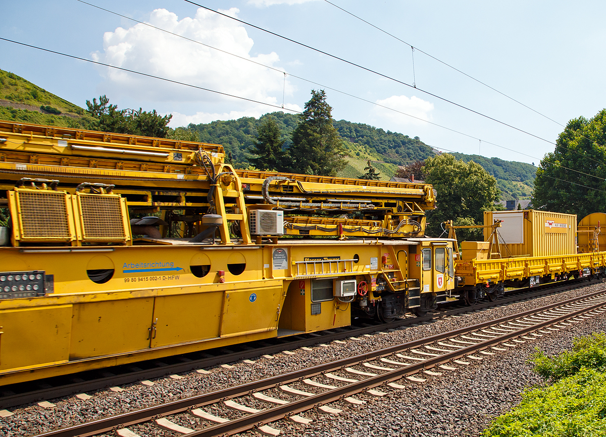 
Die Wiebe Recycling-Planumsverbesserungsmaschine mit Schotterrecycling RPMW 2002-2 am 14.07.2018 im Zugverband auf der Fahrt durch Leutesdorf,  auf der KBS 465 (Rechte Rheinstrecke) in Richtung Norden. 

Über 140 Meter lang, knapp 5 Meter hoch und gute 560 Tonnen schwer – die Gleisbaumaschine RPMW 2002-2 gehört zu den größten der Welt. Mit ihrer beachtlichen Leistung und dem umfänglichen Leistungsspektrum ist sie ein äußerst wichtiger Bestandteil des Maschinenparks der Unternehmensgruppe Wiebe.

Die Recycling Planumsverbesserungsmaschine führt verschiedene Gleisbauarbeiten durch – und das mit einer Motorengesamtleistung von über 2100 Kilowatt. Diese Kraft kommt bei Totalsanierungen zum Tragen, bei denen die RPMW 2002-2 mehrere Arbeitsschritte simultan ausführt: Die verschmutzte Schotterbettung wird ausgebaut, das abgetragene Bettungsmaterial aufbereitet, Schotter recycelt und die Unterbauplanumsschicht erneuert.

TECHNISCHE DATEN:
Hersteller: Plasser & Theurer
Baujahr, Erstzulassung: 2000
Spurweite: 1.435 mm
Anzahl der Achsen: 29, davon 12 angetrieben
Baumaschinennummer: Aushubmaschine 3369, Recyclingmaschine 3368, Antriebswagen 3367,  Stopf- u. Einschotterungsmaschine 3370
Motoren: Caterpillar 
Leistung: 2.860 PS
Gesamtlänge über Puffer: 140,90 m
Breite: 3,29 m
Höhe: 4,65 m
Gewicht: 560 t
V zul. im Zug eingestellt: 100 km/h
V max. bei Eigenfahrt: 20 km/h
Fahrradius: 120 m

Der große Unterschied zwischen Planumsverbesserungsmaschine und Bettungsreinigungsmaschinen besteht darin, dass die Planumsverbesserungsmaschine nicht nur den Schotter ausheben und recyceln kann, sondern auch einen Teil des Planums (Unterbau) ausheben (bis 1.200 mm unter SOK). Zudem kann die RPM vor der Neuschotterung (Recycling- mit Neumaterial) auch eine Planumsschutzschicht (PSS-Material) einbringen.
Der Neuschottern wird durch die Stopfeinrichtung 09-32 Stopfsatellit im Gleisbett verdichtet und das Gleis ist danach wieder mit 70 km/h befahrbar.

Hier im Bild ist der Anfang der Maschine (in Arbeitsrichtung), wo aber nicht der erste Arbeitsschritt beginnt, denn der beginnt an der Schotteraushubkette. Im Betrieb werden Materialförder- und Siloeinheit en (MFS) vor die Maschine gesetzt, zwei Förderbänder der Maschine ausgefahren und der Abraum in die MSF übergeben.