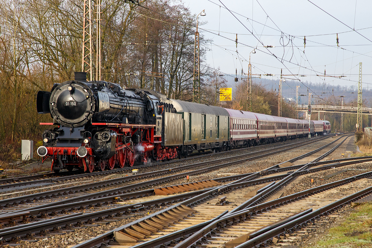 
Die Zweizylinder-Hei�dampf-Schnellzuglokomotive 01 150, ex DB 001 150-2 f�hrt am 05.12.2012, mit dem Dampfsonderzug M�nster - Hagen - Gie�en - Marburg/Lahn (DPF 79385), in den Bahnhof Kreuztal ein, wo sie zum Wasserfassen h�lt.  Am Zugschluss befand sich noch die RP 215 001 (eigentlich 92 80 1225 001-7 D-RPRS). 

Die 01 150 wurde 1935 von Henschel in Kassel mit der Fabriknummer 22698 gebaut und an die DR geliefert. Sie z�hlt nicht zu den 50 Loks, die ab 1957 auf neue geschwei�te Hochleistungskessel umger�stet wurden, sondern noch bis 2011 den vollst�ndig genieteten Altbaukessel hatte. Im Jahr 2011 erhielt sie dann einen neuen Kessel durch das DLW Meiningen mit der Fabriknummer 1542. Gekuppelt ist die Lok mit dem Tender 2'2'T 34 der 44 1112 (044 112-1), dieser wurde 1942 von Lokomotivfabrik Borsig in Berlin unter der Fabriknummer 15161 gebaut.

Die 01 150 ist Eigentum der Deutschen Bahn AG sie ist im SEH Heilbronn beheimatet und wird von der Eisenbahnstiftung Joachim Schmidt im Auftrag des Verkehrsmuseums N�rnberg betreut und betrieben. Sie hat die NVR-Nummer 90 80 0001 150-6 D-EJS. 

Die Lok sollte eigentlich vom 28.Mai bis zum 1.Juni 2014 am gro�en Dampfspektakel 2014 in der Region Pfalz-Rhein-Neckar teilnehmen. Beim Aufr�sten am 27.Mai 2014 wurde ein Anriss der rechten Felge an der hinteren Kuppelachse festgestellt, daher war ein Einsatz der Lok bei der Veranstaltung nicht mehr m�glich, sie stand aber warm im  Eisenbahnmuseum Neustadt an der Weinstra�e (Pfalzbahn - Museum), wo ich sie auch ablichten konnte. 
Siehe: http://hellertal.startbilder.de/bild/deutschland~dampfloks~br-01-db-001/359110/die-zweizylinder-heissdampf-schnellzuglokomotive-db-01-150-ex.html 
Am 02. Juni 2014 wurde die Lok unter Schmierdampf nach Heilbronn geschleppt und ging am 08.Juni weiter nach Meiningen, um dort repariert zu werden. Als Ersatz f�r die defekte Kuppelachse wurde eine Tauschachse aus Etzelwang-Lehenhammer organisiert. Nach Aufarbeitung und Einbau der Kuppelachse wurde am 16.Juli 2014 eine Probefahrt durchgef�hrt. Nach der Probefahrt wurde an der zweiten Vorlaufachse ein verdrehter Radreifen festgestellt. Um unterschiedliche Laufkreisdurchmesser am Vorlaufdrehgestellt zu vermeiden, wurde entschieden beide Achsen neu zu bereifen. Im September 2014 erhielt die Lok die neuen Radreifen f�r die beiden Achsen im Vorlaufdrehgestell.
