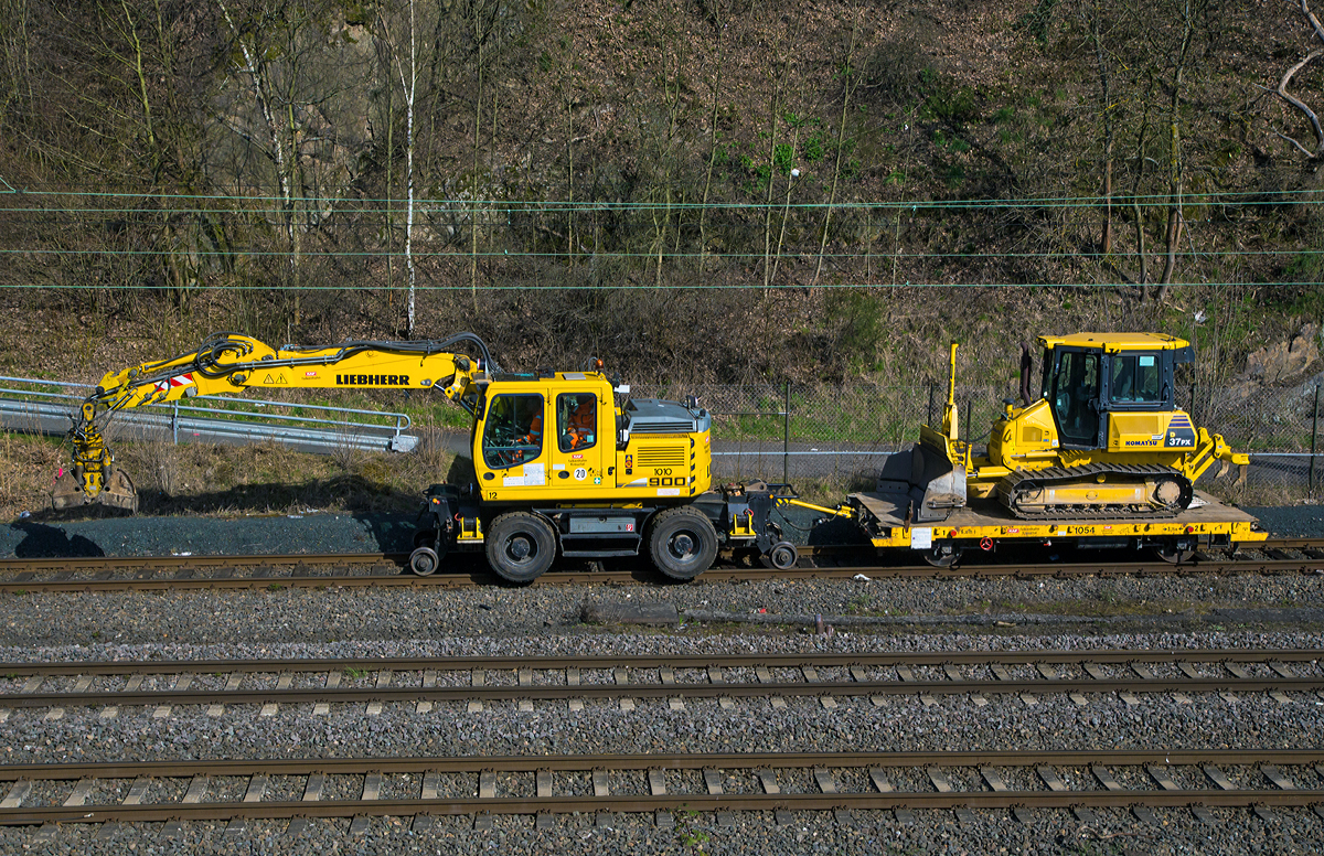 Ein etwas anderer Zugverband....
Ein Liebherr A 900 C ZW Li (Litronic) / 1031, Zweiwegebagger mit Vier-Punkt-Abst�tzung der KAF Falkenhahn Bau AG, Kreuztal (Nr. 12) mit einem Gleiskraftwagenanh�nger Kla 03, beladen mit einer Komatsu Planierraupe D37PX, am 05.04.2015 beim Hauptbahnhof Siegen.