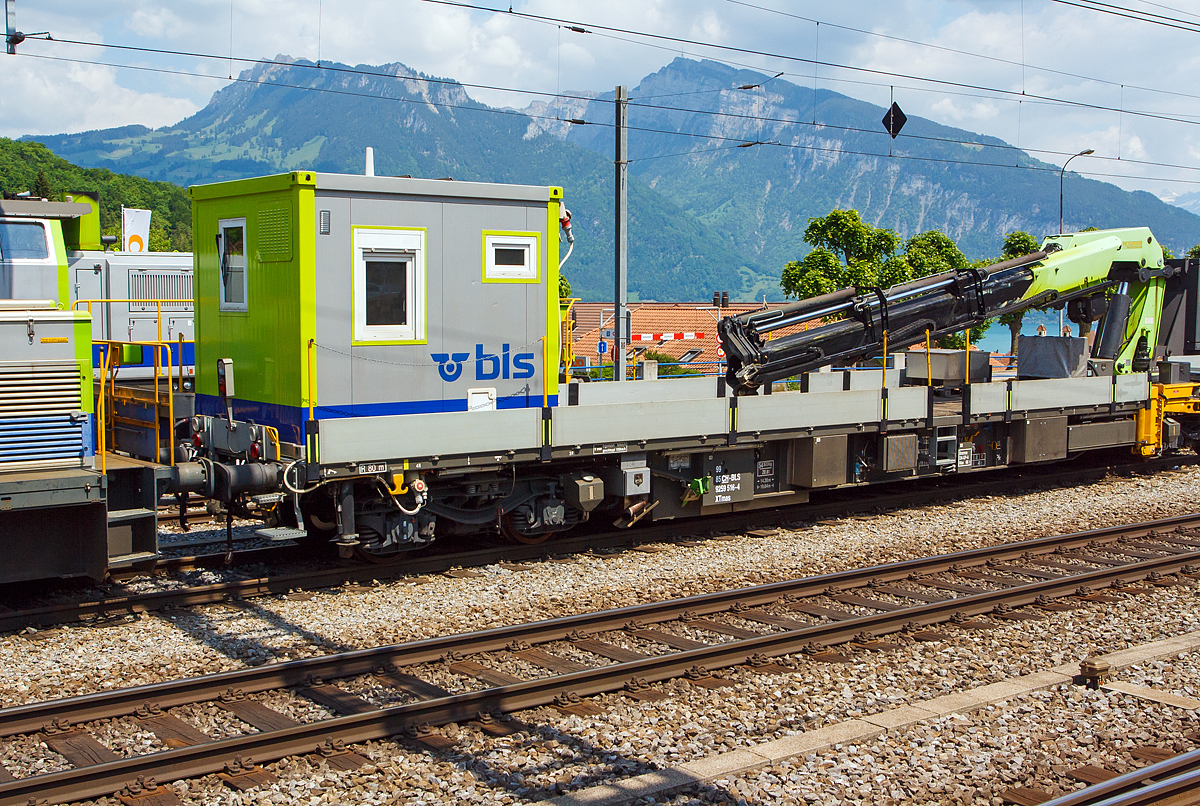 
Erhaltungsfahrzeug EHF bzw. der selbstfahrende Dienstwagen XTmas 516 mit Palfinger Kran 100002 D 100mt  (99 85 92 59 516-4 CH-BLS) abgestellt am 28.05.2012 beim Bahnhof Spiez (aufgenommen aus einfahrendem Zug).

Für die Durchführung der Arbeiten innerhalb der Erhaltungsabschnitte werden Erhaltungsfahrzeuge (EHF)  mit modularen, den jeweiligen Anforderungen entsprechenden, Aufbauten und Ausrüstungen eingesetzt.
Im Laufe des Jahres 2006 erhielt die BLS insgesamt 13 Erhaltungsfahrzeuge von der Firma SCHÖRLING-BROCK GmbH in Gehrden bei Hannover. Von den13 Fahrzeugen besitzen 9 einen hydrostatischen Antrieb, der den Eigenbetrieb bis zu einer Geschwindigkeit von 60 km/h erlaubt, der geschleppte Betrieb ist bis 100 km/h zugelassen. Die UIC-Konformität der Konstruktion ist gegeben. Die Fahrzeuge sind im Konzept eines 60“-Containerwagens gestaltet mit unterschiedlichen Aufbauten und einem Leergewicht zwischen 21 t für einen nicht angetriebenen und 47 t für diesen angetriebenen Tragwagen mit aufgebautem 100mt-Kran und 14 Tonnen Gegengewicht. Bei dem einheitlichen Gesamtgewicht aller Wagen von 72 t ergeben sich somit für Baufahrzeuge beachtliche Zuladungskapazitäten.

Die geringe Ladehöhe von 1.140 mm sowie die maximale Pufferhöhe von 990 mm ergeben mit der damit einhergehenden Überlademöglichkeit für Langgut vielseitige Anwendungsmöglichkeiten.
Die Bremsanlage wird generell mit einer Federspeicherbremse ergänzt. Bei den angetriebenen Fahrzeugen ist neben der Lokbremse auch noch eine Anhängerbremse vorhanden.

Technische Daten Grundfahrzeug mit Antrieb:
Angetrieben werden jeweils die inneren Achsen der Drehgestelle mittels Hydrostat und Getriebe von einem 210 kW starken Deutz-Motor mit Partikelfilter der Fa. Hug Engeneering AG.
Der Energiebedarf der Aufbauten oder von Werkzeugen neben dem Fahrzeug wird von einem hydrostatisch angesteuerten Generator mit 50 bzw. 60 kVA gewährleistet. Um eine möglichst tief liegende Ladefläche verwirklichen zu können, kommen vom UIC-Standarddrehgestell Y31 abgeleitete Drehgestelle der Bauart Y31Lssif-D-(AK) von der Firma Eisenbahn Laufwerke Halle (ELH) zum Einsatz, welche sich bei einem Neuraddurchmesser von 760mm durch eine tief liegende Abstützebene für das Untergestell auszeichnen
Für Start, Beleuchtung und Gewährleistung von Notfunktionen über eine EPumpe stehen 24 V/630 Ah Batteriekapazität zur Verfügung.
Als Steuerungselektronik kommen fahrzeugtaugliche Digsy Outdoor-Komponenten der Firma Intercontrol mit einer Funkfernsteuerung der Firma Theimeg zum Einsatz. Diese Kombination ist bereits auf Baudienstfahrzeugen der Deutschen Bahn AG im Einsatz.
Neben den Kranaufbauten werden variabel aufsetzbare Aufbauten wie Kabelrollböcke, Arbeitsbühnen sowie Mannschafts- und Magazincontainer mit 10 Fuß und 20 Fuß Länge eingesetzt.
Fixe und abnehmbare Aufbauten sind als Mannschaftsraum und WC ausgebildet.
Zum Einsatz der Funkfernbedienung mit V-Max 80 km/h sind diese mit Notbremsventil ausgeführt. Die Steuerung der Erhaltungsfahrzeuge erfolgt im Fahrbetrieb generell mit einer Theimeg-Funkfernsteuerung. Im Kranbetrieb erfolgt die Versetzfahrt mit bis zu 9,5 km/h über die Kranfernbedienung. Als Rückfallebene dient eine Kabelfernbedienung (bis 40 km/h).

Bei der BLS werden folgende Ausbildungen von angetriebenen Erhaltungsfahrzeugen (EHF) eingesetzt:
3 Fahrzeuge für Mannschaft, Material und Werkzeug mit ca. 8,0 m freier Ladeflächenlänge, asymmetrisch aufgebautem Kran (ca. 14 mt) für die Manipulation von Paletten und leichten Gütern sowie die Unterstützung von Arbeitsprozessen.
5 Fahrzeuge mit Kran (20 mt) bzw. dreiteiliger Arbeitsbühne und Fahrleitungsdrückanlage. 2 Kräne sind auch mit Arbeitskorb für die Fahrleitungsmontage ausgerüstet.
1 Fahrzeug (dieses hier) mit großem Kran (ca.100 mt) mit dem für die Störungsintervention zusammen mit einem anderen Fahrzeug auch die Zungenvorrichtungen der Schnellfahrweichen mit bis zu 64 m Länge und Herzstücke mit bis zu 7,5 t Gewicht und 22,5 m Länge transportiert und manipuliert werden können
Fünf weitere von der BLS AG selbstgebaute Fahrzeuge kamen 2012 und 2013 (XTmas 521-525)  hinzu. 2x mit Kran PKR 200 C (20 mt), 1x mit PKR 480 D (48 mt) und 2x mit Kran PK 29002 C (29 mt). Diese Fahrzeuge haben ein Deutz-Dieselmotor vom Typ TCD 7.8 L6 mit 230 kW Leistung.

TECHNISCHE DATEN:
Spurweite: 1.435 mm (Normalspur)
Achsfolge: (1Ao)  (Ao1)
Wagenlänge über Puffer: 19.640 mm
Drehzapfenabstand: 14.200 mm
Achsstand im Drehgestell: 1.800 m
Bruttogewicht aller dargestellten Fahrzeuge:  72 t
Eigengewicht  (XTmas 516): 54.5 t
Ladegewicht  (XTmas 516):  17.5 t
Ladelänge:  18.300 mm
Ladebreite:  2.760 mm
Ladehöhe:  1.150 mm
Pufferhöhe über SOK (Neuzustand ohne Beladung): 990 mm
Drehgestelle: Y31Lssif-D-(AK)
Raddurchmesser neu / abgenutzt:  760 / 700 mm
Motorleistung: 210 kW
Dieselmotor Typ:  Deutz BF 6M 1013 FC EURO III
Partikelfilter: mobiclean S / Hug Engeneering AG
Antriebsart: hydrostatisch, jeweils auf die innenliegende Achse der Drehgestelle
Bremsanlage: direkte Druckluftbremse,indirekte Druckluftbremse DK-GP-A, Hydrostatische verschleiß freie Bremse, Feststellbremse als Federspeicher (separat ansteuerbar).
Feststellbremse Federspeicher:  bis 40 ‰
Maximale Geschwindigkeit Eigenantrieb:  60 km/h
Maximale Geschwindigkeit geschleppt: 100 km/h
Maximale Geschwindigkeit Kranbetrieb:  9,5 km/h

Fünf weitere von der BLS AG selbstgebaute Fahrzeuge kamen 2012 und 2013 (XTmas 521-525)  hinzu. 2x mit Kran PKR 200 C (20 mt), 1x mit PKR 480 D (48 mt) und 2x mit Kran PK 29002 C (29 mt). Diese Fahrzeuge haben ein Deutz-Dieselmotor vom Typ TCD 7.8 L6 mit 230 kW Leistung.
