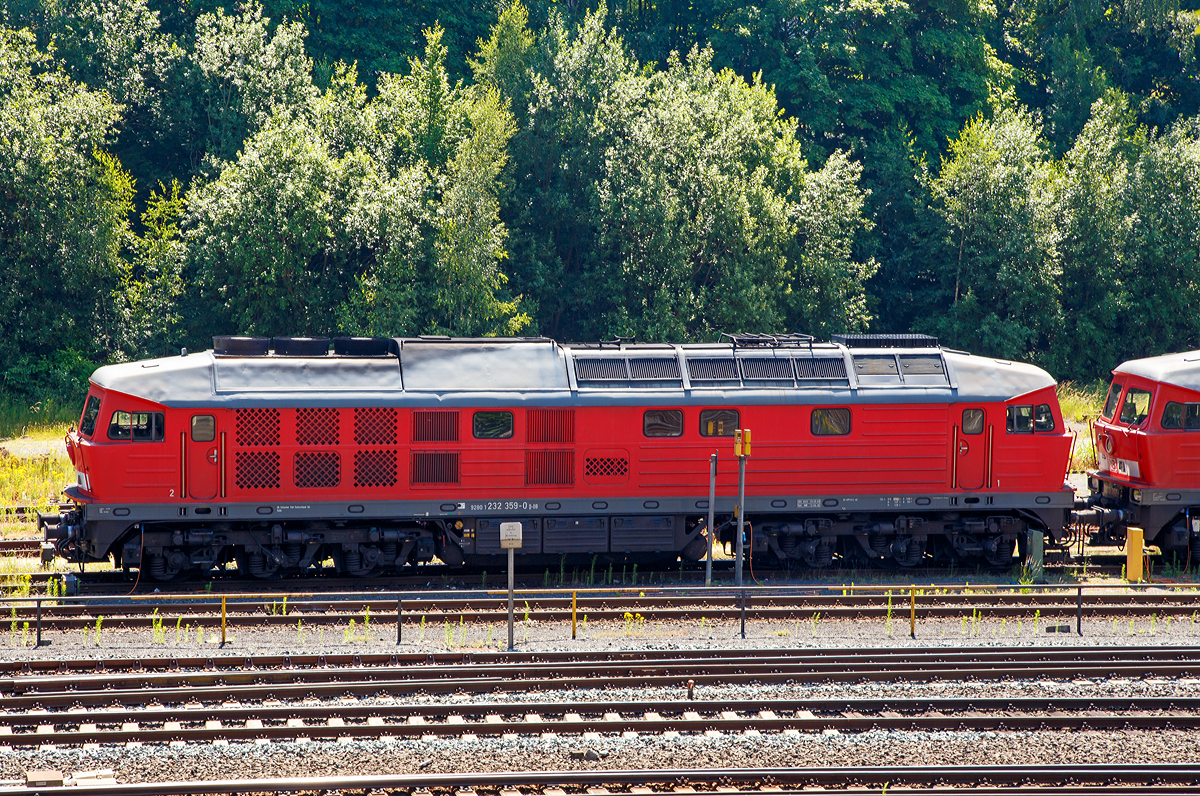 
Für dieses erste brauchbares Bild von einer Ludmilla bin ich einmal, das bei über 30 Grad Hitze,  um das ganze Bahnhofareal gelaufen ..........
Die 232 359-0 (92 80 1232 359-0 D-DB), ex DR 132 359-1, ist am 01.07.2015 in Marktredwitz (Fichtelgebirge / Oberfranken) abgestellt.

Die Ludmilla wurde 1976 von Lokomotivfabrik Oktober-Revolution, Woroschilowgrad  (Sowjetunion) unter der Fabriknummer 0594 und als 132 359-1 an die DR geliefert. 

Die Diesellokomotiven der DR Baureihe 130 (DB 230), 131 (DB 231), 132 (DB 232, 233, 234, 241 und 754) und 142 (DB 242) wurden ab 1970 aus der damaligen Sowjetunion in die DDR importiert und bei der Deutschen Reichsbahn für den Personen- und Güterverkehr in Dienst gestellt. Die Baumuster wurden noch als V 300 auf der Leipziger Messe vorgestellt.

Von der Baureihenfamilie wurden zwischen 1970 und 1982 insgesamt 873 Stück in Dienst gestellt. Nach 1990 kam die unter Eisenbahnern ungebräuchliche Bezeichnung Ludmilla auf. 

Ab 1973 war der Hersteller endlich in der Lage, Lokomotiven mit elektrischer Zugheizung zu liefern. Die ersten beiden Probemaschinen (Baujahr 1972) waren noch für eine Höchstgeschwindigkeit von 140 km/h zugelassen und wurden daher als 130 101 / 102 bezeichnet. Sie wurden bei der DB AG zuletzt sogar noch als Bahndienstfahrzeuge der Reihe 754 zugeteilt.

Da überhaupt nicht absehbar war, wann die zulässigen Streckenhöchstgeschwindigkeiten erhöht werden könnten, entschied man sich bei allen folgenden Exemplaren für eine reduzierte Höchstgeschwindigkeit von 120 km/h. Diese wurden ab 1974 als Baureihe 132 in Dienst gestellt. Insgesamt wurden 709 Stück dieser Baureihe gebaut.

Die Baureihe 132 war universell einsetzbar, sowohl im hochwertigen Schnellverkehr als auch im schweren Güterzugdienst. Nebenstrecken mit weniger als 20 t Achslast konnte die BR 132 nicht befahren.

Die Leistung wird von einem direkteinspritzenden 16-Zylinder-Viertakt-Dieselmotor vom Typ Kolomna 5D49 bereitgestellt. Der Motor liefert mit Turbolader und Ladeluftkühler 2.200 kW (3.000 PS). Der Dieselmotor treibt außer der Licht- und Erregermaschine vor allem einen Drehstromhauptgenerator und einen Drehstromheizgenerator an.

Die Kraftübertragung erfolgt elektrisch. Der Traktionsstrom wird über eine Sechs-Wege-Gleichrichtung von 240 Dioden in Gleichstrom gewandelt. Die Leistungsregelung erfolgt über die Dieselmotordrehzahl und einen Thyristorfeldregler der Erregermaschine.

Technische Daten der BR 232:
Hersteller: 	Lokomotivfabrik Woroschilowgrad (heute Luhansk)
Spurweite: 	1435 mm (Normalspur)
Achsformel: Co’Co’
Länge über Puffer: 20.820 mm
Drehgestellachsstand: 1850 mm
Dienstgewicht: 124,7 t
Radsatzfahrmasse:  20,4 t 
Höchstgeschwindigkeit: 120 km/h
Stundenleistung: 2200 kW
Treibraddurchmesser: 	1050 mm
Motorentyp: Kolomna 5 D 49 /16 Tsch N 26/26
Leistungsübertragung: elektrisch
Tankinhalt: max. 6000 l
Anzahl der Fahrmotoren: 6
