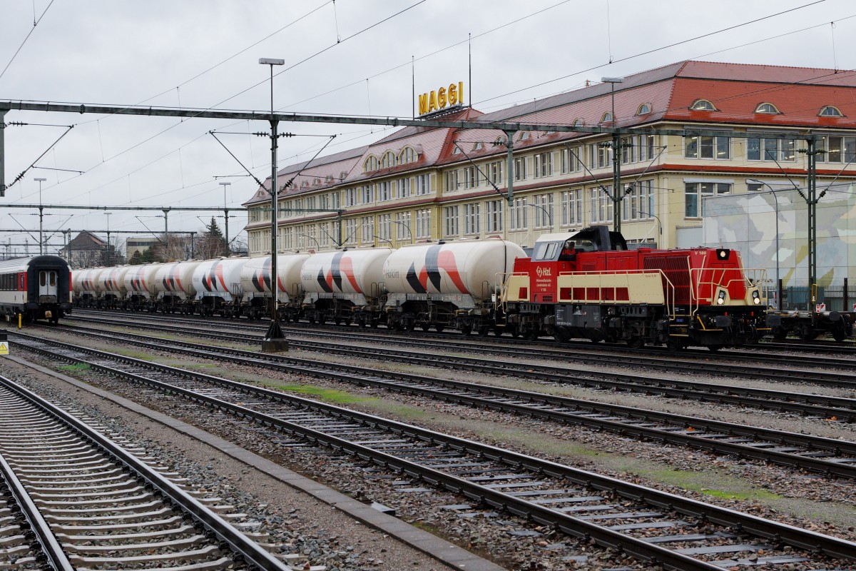 HZL: Die V 180 Gravita 15 L BB mit einem HOLCIM-BLOCKZUG in Singen vor der Kulisse der MAGGI FABRIK, dem Wahrzeichen des Bahnhofs Singen, am 20. November 2015 kurz vor der Abfahrt nach ????
Foto: Walter Ruetsch