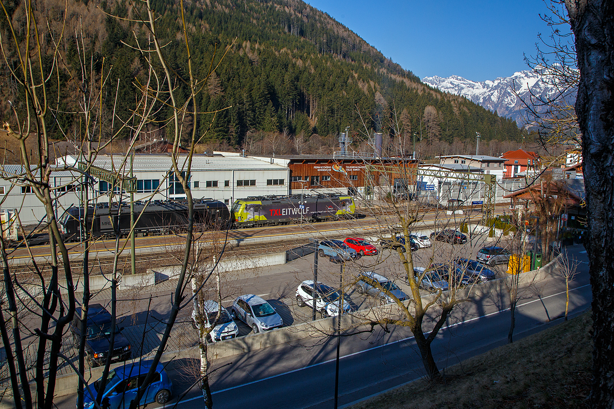 In Doppeltraktion fahren die beiden an die TX Logistik AG vermieteten Siemens Vectron MS am 28.03.2022 mit einem KLV-Zug durch den Bahnhof Gossensaß/Colle Isarco zum Brenner/Brennero hinauf. Vorne der „TX LEITWOLF“ 193 554 (91 80 6193 554-3 D-ATLU) der Alpha Trains Belgium und dahinter die schwarze MRCE Dispolok X 4 E – 654 bzw. 193 654 (91 80 6193 654-1 D-DISPO). Beide Loks haben die Zulassung für Deutschland, Österreich und Italien. 

Die 193 554 wurde 2016 unter der Fabriknummer 22194 und die 193 654 wurde 2017 unter der Fabriknummer 22196 von Siemens Mobilitiy in München-Allach gebaut.