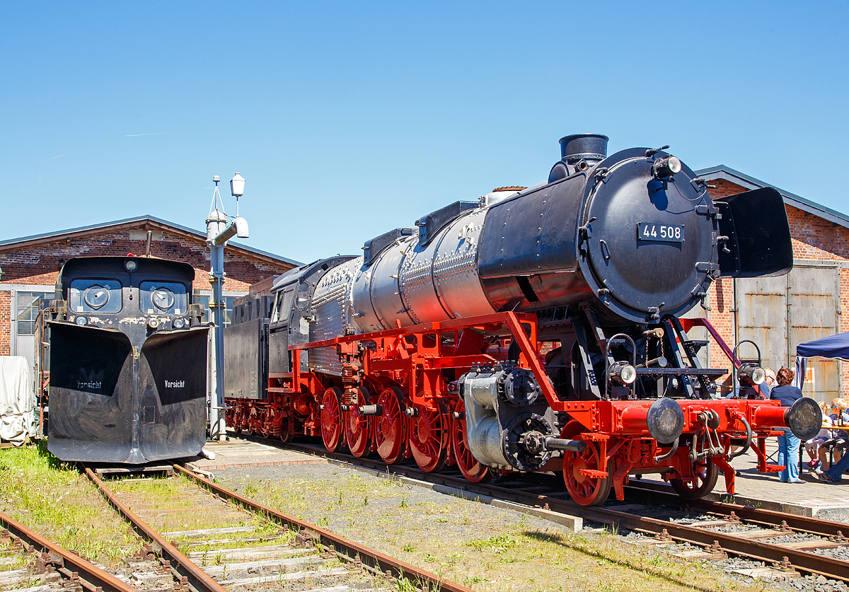 Man sieht es sehr deutlich, der Verein hat noch viel Arbeit an dem  Jumbo  vor sich, denn die Treib- und Kuppelstangen sowie der �u�eren Steuerung fehlen auch noch....Die schwere G�terzug-Dampflokomotive 44 508, ex DB 044 508-0, steht am 05.05.2018 vor dem Lokschuppen vom Erlebnisbahnhof Westerwald der Westerw�lder Eisenbahnfreunde 44 508 e. V. hier war Museumstag. 

Die Lok ist Eigentum vom DB-Museum und eine Leihgabe an die Eisenbahnfreunde, die nach ihr ihren Verein genannt haben. Wie man sieht, gibt es noch viel zu tun bis sie wieder im alten Glanz erstrahlt.

Die Dampflokomotive 44 508 wurde im Jahr 1941 von der Lokomotivfabrik Krauss-Maffei in M�nchen unter der Fabriknummer 16113 gebaut und an die DR geliefert. Nach dem Krieg blieb sie im Westen und wurde so 1949 als 44 508 in den Bestand der Deutsche Bundesbahn aufgenommen, mit der Einf�hrung des EDV-Nummernschemas wurde sie zum 01.01.1968 in 044 508-0 umgezeichnet. Seit Mitte der 1950er Jahre ist sie gekuppelt mit dem 2'2'T34 Tender der ex �BB 44 1561 (Borsig Lokomotiv-Werke GmbH, Hennigsdorf-Berlin, Baujahr 1940, Fabriknummer 15400). Bis zu ihrer Au�erdienststellung im Mai 1977, im BW Gelsenkirchen-Bismarck legte sie eine Strecke von �ber 1.9 Millionen Kilometern zur�ck.

Bis zur Abl�sung durch moderne Diesel- und Elektrolokomotiven waren die Maschinen der Baureihe 44 das R�ckgrat des schweren G�terzugdienstes in Deutschland.

Die deutschen Eisenbahner nannten die Baureihe 44 wegen ihrer Zugkraft auch  Jumbo“. Erst die von der Deutschen Reichsbahn zwischen 1958 und 1962 rekonstruierten Lokomotiven der Baureihe 58.30 reichten im Flachland an das Leistungsniveau der Baureihe 44 heran. Die wenigen Maschinen der Baureihe 45 hatten zwar eine h�here Endgeschwindigkeit und Leistung, verf�gten aber nicht �ber eine h�here Zugkraft.     

Bei der DB konnten sich kohle- und �lgefeuerte Loks fast gleich lang im Betrieb halten. Als letzte kohlegefeuerte Lokomotive der Baureihe 44 wurde diese (hier ausgestellt) DB 044 508-0 im Mai 1977 im Bw Gelsenkirchen-Bismarck ausgemustert. Somit war diese Lok hier die letzte kohlegefeuerte Lok der DB im Plandienst. 

Als letzte Leistung bef�rderte 043 903-4 (�lbefeuert) am 26. Oktober 1977 f�r das Neubauamt Nord den Zug 81453 (bestehend aus einem Hilfszug-Ger�tewagen) von Oldersum nach Emden Rbf, es war gleichzeitig die letzte planm��ig mit Dampflok bef�rderte Zugleistung der Deutschen Bundesbahn. 