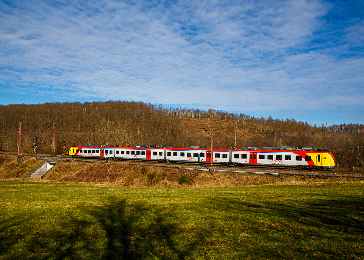 Man sieht nun auch vierteilige HLB  Grinsekatzen  auf der Dillstrecke....
Der ET 157 (94 80 1440 657-3 D-HEB / 94 80 1441 657-2 D-HEB / 94 80 1441 157-3 D-HEB / 94 80 1440 157-4 D-HEB) ein vierteiliger Niederflur-Elektrotriebwagen vom Typ Alstom Coradia Continental der HLB (Hessische Landesbahn), fährt am 02.03.2022 als RE 99 (Gießen - Siegen) und erreicht bald den Hp Rudersdorf (Kr. Siegen).

Der vierteilige Niederflur-Elektrotriebwagen wurde 2018 von ALSTOM Transport Deutschland GmbH in Salzgitter unter den Fabriknummer D041531-004 (A1, B, C und A2) gebaut und an die HLB geliefert. 

Die Triebzüge Alstom Coradia Continental gehören zur Fahrzeugfamilie modularer, niederfluriger elektrischer Nahverkehrs-Gliedertriebzüge Alstom Coradia. Die Züge werden aus einem Baukasten standardisierter Einzelfahrzeuge gebildet, die ihre technische Ausrüstung mit Ausnahme der Fahrmotoren auf dem Dach tragen. Die Endwagen tragen jeweils einen Haupttransformator, einen Antriebsumrichter und einen Nebenbetriebsumrichter. Die Mittelwagen tragen die weiteren Ausrüstungen Stromabnehmer, Kompressor und Batteriekasten. Mittig auf jedem Fahrzeug ist das Klimagerät für den Fahrgastraum angeordnet.

Die Hessische Landesbahn hat insgesamt 30 dieser neuen Niederflur-Elektrotriebzüge gekauft, 17 vierteilige und 13 dreiteilige ET. Am 27. Juli 2018 erhielten die Züge ihre Zulassung und werden seitdem Probebetrieb eingesetzt. Zudem wurden noch 5 weitere bestellt.

Die Züge erreichen im Einsatz Geschwindigkeiten von bis zu 160 km/h und besitzen ein sehr gutes Beschleunigungsvermögen. Sie können je nach Fahrgastaufkommen auch in Doppeltraktion betrieben werden. Durch ein speziell für Regionalzüge modifiziertes Zugsicherungssystem können die Fahrzeuge auch auf ICE-Strecken fahren. Die Triebzüge sind zudem mit elektrischen Bremsen ausgestattet, die in der Lage sind, beim Bremsvorgang bis zu 30 Prozent der Energie ins Netz zurück zu speisen.

TECHNISCHE DATEN der BR 1440.1:
Hersteller: Alstom Transport Deutschland GmbH
Spurweite: 1.435 mm
Achsfolge: Bo‘(Bo‘)(2’ )(Bo‘)Bo‘ in Klammern Jakobs-Drehgestelle
Länge über Kupplung: 73.300 mm
Breite: 2.920 mm
Drehzapfenabstände: 15.500 / 16.400 / 16.400 / 15.500 mm
Achsabstand im Enddrehgestell: 2.400 mm
Achsabstand im Drehgestell: 2.700 mm
Maximale Höhe (über SO): 4.280 mm
Eigengewicht: 144 t
Minimaler befahrbarer Gleisbogen Werkstatt/Betrieb: 100/150 m
Niederfluranteil: ca. 89 %
Sitzplätze: 227 (davon 12 in der 1. Klasse)
Stromsystem: 15 kV / 16,7 Hz
Höchstgeschwindigkeit: 160 km/h
Nennleistung: 2.900 kW
Anzahl Fahrmotoren: 8
Zugbeeinflussungs-System: LZB / PZB 90

