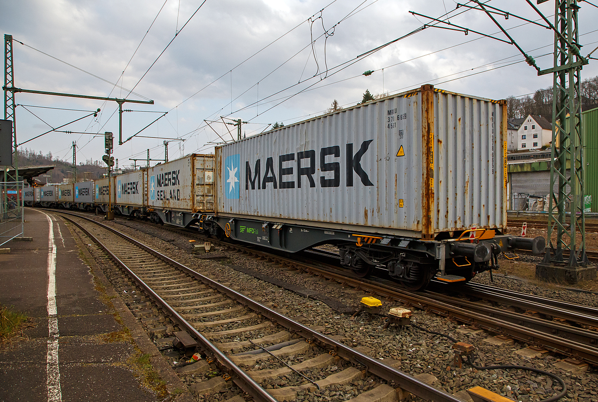 Sechsachsige Gelenk-Drehgestell Containertragwageneinheiten 90´ am 20.03.2022 im Zugverband bei der Zugdurchfahrt im Bf Betzdorf (Sieg), hier im Vordergrund der Wagen 37 80 4963 237-5 D-MFDR, der Gattung Sggmrss M4 (90´), der MFD Rail GmbH (Schweiz).

Diese Gelenkwagen mit sechs Radsätzen sind für den Transport von Großcontainern und Wechselbehältern vorgesehen. Auf den Außenlangträger des Wagens befinden sich für jede vorgesehene Ladeposition feste und klappbare Aufsetzzapfen zum Festlegen der Ladungseinheiten in verschiedenen Kombinationen. 

TECHNISCHE DATEN:
Spurweite: 1.435 mm
Länge über Puffer: 29.590 mm
Drehzapfenabstand: 2 x 12.025 mm
Achsabstand in den Drehgestellen: 1.800 mm
Drehgestelle: 3 x Y25 Ls-K
Laufraddurchmesser: 920 mm (neu)
Ladelänge: 2 x 13.800 mm
Höhe der Ladeebene über S.O.: 1.155 mm
Eigengewicht: 27.500 kg
Max. Zuladung bei Lastgrenze S: 107,5 t (ab Streckenklasse D)
Max. Zuladung bei Lastgrenze SS: 92,5 t (ab Streckenklasse C)
Max. Geschwindigkeit: 100 km/h (Lastgrenze SS und leer 120 km/h)
Kleinster befahrbarer Gleisbogen: R 75 m (Einzelwagen) / R 150 m (Zugverband)
Bremse: 2 x KE-GP-A (Max. 108 t)
Bremssohle: Jurid 816M 320
Feststellbremse: Ja
Intern. Verwendungsfähigkeit: TEN-GE
