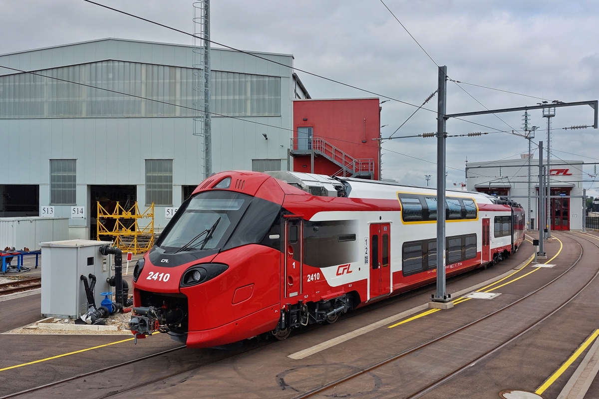 Triebzug 2410 steht in der Abstellung neben der Stra�enbahnhaltestelle: Lyc�e Bonnevoie, gesehen als wir an der Haltestelle ausgestiegen sind, von der Stra�e aus mit dem H�ndy durch den Zaun aufgenommen. 24.07.2024  
Dieser Triebzug wurde am 28.09. als erster dieser Baureihe, offiziell im Regelverkehr eingesetzt. 