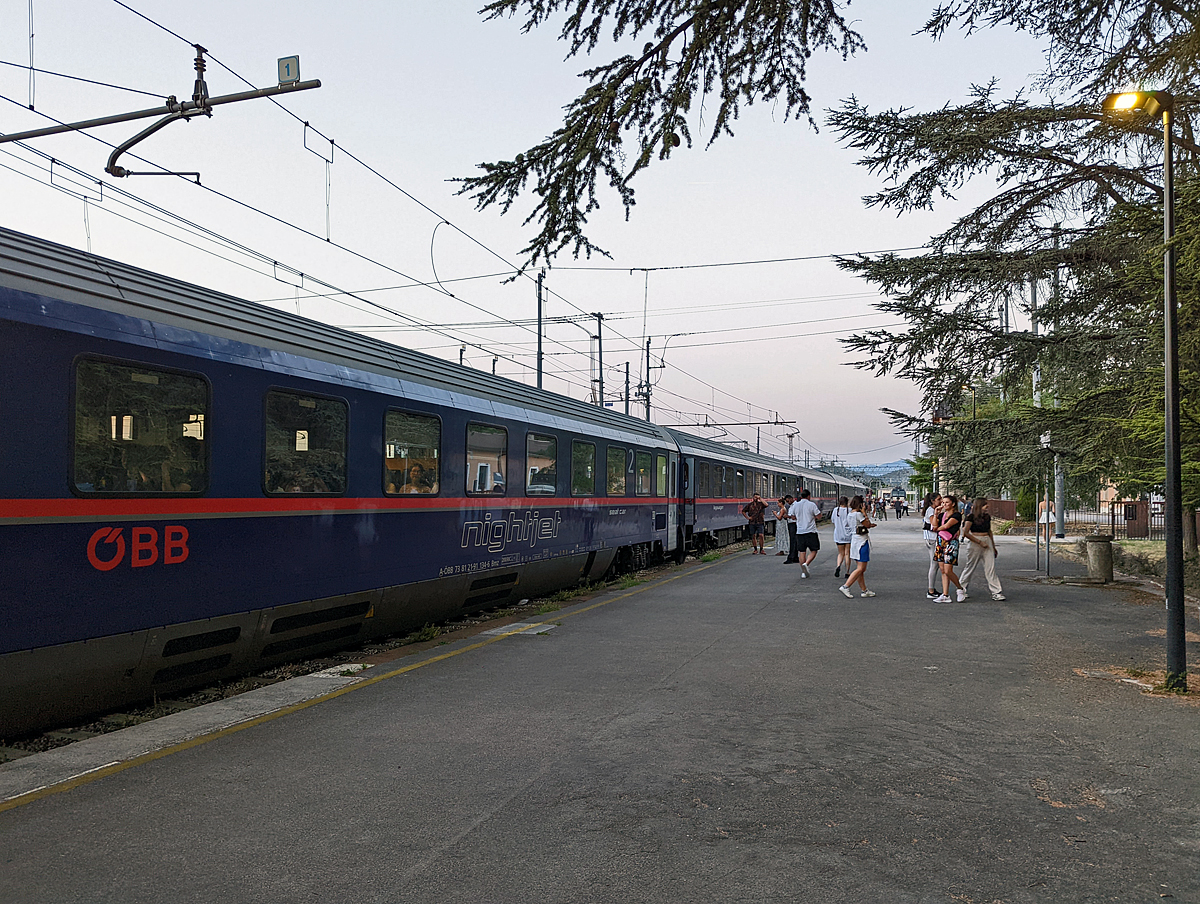Unser ÖBB Nightjet 236/40236 von Venezia nach Wien/München musste am 24.07.2022 eine Umleitung über Slowenien fahren. Hier beim Lokwechsel- und Grenzkontrollenhalt im italienischen Grenzort Villa Opicina. Wenn ich gewusst hätte wie umfangreich und lange die Grenzkontrolle dauert, so wäre ich mal nach vorne gelaufen und hätte die Zuglok abgelichtet, aber ich blieb doch sicherheitshalber bei der Tür.