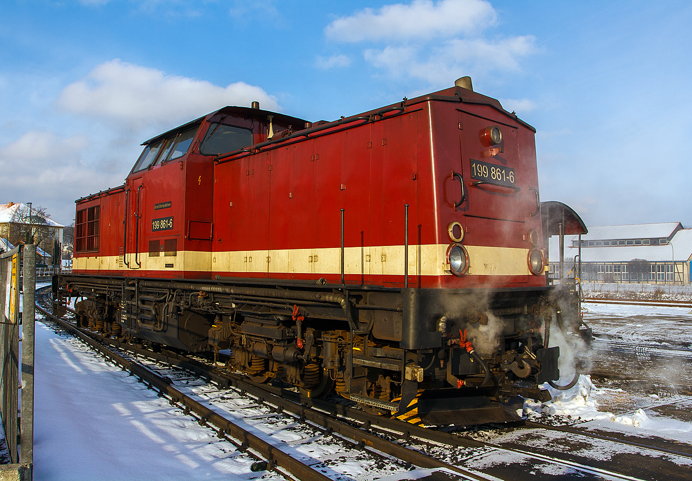 Das  Rote Kamele , auch bekannt als  Harzkamel , 199 861-6 der HSB (Harzer Schmalspurbahnen), ex DR 110 861-2, ex DR 299 110-7, am 23.03.2013 im Bf Wernigerode. 

Wie man es hier schon aus den ehemaligen Nummern der DR sehen kann, handelt es sich bei dieser Diesellok um eine ehemalige normalspurige V 100.1 der DR. Sie wurde als normalspurige V 100.1 im Jahre 1976 bei LEW  Hans Beimler  in Hennigsdorf unter der Fabriknummer 15379 für die DR gebaut. 1990 erfolgte der Umbau in DR 199 861-6 dabei bekam die B'B'-Lok nun neue 3-achsige Drehgestelle in 1.000 mm Spurweite, 1992 wurde sie dann in DR 299 110-7 umbezeichnet, als sie 1993 von der HSB übernommen wurde, bekam sie wieder die Bezeichnung 199 861-6.

In der ehem. DDR hatte in den 80er-Jahren der Güterverkehr auf der Schiene eine größere Bedeutung als etwa bei der Deutsche Bundesbahn in der Bundesrepublik. Das lag zum einen an dem schlechten Zustand der Fernverkehrsstraßen, zum anderen am mangelnden Bestand an leistungsfähigen Lastkraftwagen in der DDR. Im Harz zogen die schmalspurigen Neubauloks in Doppeltraktion Kohlezüge. Mit dem verstärktem Güterverkehr im Südharz und der notwendig gewordenen Abordnung von Neubaumaschinen ins Selketal, wurden Mitte der achtziger Jahre die Loks knapp.

Woher sollten die Dieselloks mit 1.000 mm Spurweite nur kommen. Die damalige DDR war vertraglich fest an den RGW (Rat für gegenseitige Wirtschaftshilfe) gebunden. Daher durfte sie keine Dieselloks mehr bauen! Aber mit Diesellok aus anderen Bruderländern hatte man schlechte Erfahrungen, so faste man den Entschluss, im Rahmen einer Rekonstruktion eine bewährte deutsche Lokomotive für die Harzer Schmalspurbahnen umzubauen.

Wobei sich die Umkonstruktion jedoch in die Länge zog. Bereits 1982 sprach man davon - doch erst im Dezember 1988 stand die erste Maschine auf dem Hof in Wernigerode. Die Lokomotiven wurden vom RAW Stendal, wo der Umbau erfolgte, auf Schleppgestellen nach Wernigerode verbracht. Hier wurden die Loks angehoben und mit Schmalspurdrehgestellen versehen.
Neben der Spurweite, ist ein ganzgroßer Unterschied in den Drehgestellen ersichtlich. Während die Normalspurloks die Achsfolge BB haben, hat die Schmalspurvariante, um die Achslast zu reduzieren, die Achsfolge CC. Auch die Zug- und Stoßvorrichtung (Puffer und Zughaken) wurden am Drehgestell angebracht, nicht wie bei der Regelspur am Rahmen (die alte Befestigungslöcher kann hier noch gut sehen).

Dadurch wird die Zugkraft zum Teil über die Drehzapfen der Drehgestelle übertragen. Aus diesem Grund dürfen die 199 8 nicht zum Zweck der Zugkrafterhöhung (Doppeltraktion) zusammen gekuppelt werden.
Interessant ist auch der Tausch von Primär- und Sekundärfederung. Während bei der Normalspur Schraubenfedern zur Federung des Drehgestells zum Hauptrahmen dienen, findet man diese bei der Schmalspur zu Federung jeder einzelnen Achse. Umgekehrt ist bei der Normalspur die einzelne Achse mit Gummischubdruckelementen gefedert, bei der 199.8 dienen diese Elemente zum Federn des Drehgestells.

An der eigentlichen Lokomotive gibt es nur wenige Änderungen. Trotzdem ist es manchmal nicht ganz einfach auf den Führerstand zu kommen, denn die Schmalspurausführung ist 11cm höher als ihr Original.

Bevor die  Roten Kamele  eingesetzt werden konnten, mussten noch einige Veränderungen an den Strecken vorgenommen werden. Dies wurde notwendig, da das Lichtraumprofil der Dieselloks an einigen Stellen das der Strecke überschritt. In einige Gleise dürfen die 199.8 auch heute noch nicht hinein. Sie passen teilweise auch nicht in den Lokschuppen hinein, darum findet man manchmal ein Schild  Halt für BR 199.8! .

Umgebaut wurden insgesamt zehn Loks der Serie V 100.1 mit 800er Ordnungsnummer – die Nummer blieb unverändert bestehen. Geplant waren sogar dreißig Loks umzubauen und alle Dampfloks zu ersetzen und zu auszumustern. Durch die politische Wende blieb es allerdings bei den zehn Lokomotiven, welch ein Glück im doppelten Sinne (Wiedervereinigung und der Erhalt der Dampfloks).

Im Rahmen der Vereinigung der beiden deutschen Staatsbahnen Deutsche Bundesbahn und Deutsche Reichsbahn war es erforderlich, ein einheitliches System zu schaffen. Daher kam es ab dem 01.01.1992 (Gemeinsames Baureihenschema DR und DB) noch zur Umzeichnung der Loks in die Baureihe 299.
Durch die politische Wende bzw. Wiedervereinigung Deutschlands zeichnete sich ab, dass die Schmalspurbahnen im Harz unter Regie der DR keine Zukunft haben werden. Über eine kommunale Gründungsgesellschaft entstand am 13. März 1991 das private Eisenbahnverkehrsunternehmen (EVU)  Harzer Schmalspurbahnen GmbH (HSB) . Am 01.02.1993 übernahm die HSB die Strecken, die Anlagen, die Fahrzeuge und den größten Teil der bei den Schmalspurbahnen im Harz tätigen Mitarbeiter der DR. Seit diesem Tag ist die HSB zuständig für den Betrieb auf den Harzer Schmalspurbahnen. Gesellschafter der HSB sind die Landkreise Harz und Nordhausen, die an der Strecke liegenden Kommunen, die Stadt Quedlinburg, die Gemeinde Tanne sowie die Kurbetriebsgesellschaft Braunlage.
Nun wurden auch die Loks wieder zurück umgezeichnet in BR 199.8.

Die HSB unterhält heute (seit der Streckenverlängerung 2006 von Gernrode nach Quedlinburg) ein Schmalspur-Streckennetz von 140,4 km Länge mit 42 Bahnhöfen und Haltepunkten.

Drei Lokomotiven (199 861-6, 872-3 und 874-9) wurden 1998 bei Adtranz in Kassel modernisiert, sie bekamen eine Funkfernsteuerung und zwei Loks zusätzliche Normalspurpuffer für den Rollbockverkehr auf entsprechender Höhe vorne und hinten angebaut, bei der hinteren 199 872-3 (die auch z.Z. die einzige ist die sie hat) kann man die noch oben geklappten Puffer deutlich sehen. Vier überzählige gleichzeitig verkauft und diese wurden danach zu Normalspurfahrzeugen zurückgebaut. Die drei anderen nicht modernisierten Lokomotiven (199 871-5, 877-2 und 892-1) wurden mangels Bedarf und wegen Fristablauf abgestellt.

Technische Daten der BR 199.8:
Achsfolge: C´C´
Spurweite: 1.000 mm (Meterspur)
Länge über Puffer: 14.240 mm
Motor: 12-Zylinder-4 Takt-Diesel-V-Motor mit Abgasturbolader und Ladeluftkühler
Leistung: 883 KW / 1200 PS
Getriebe: 3-Wandler Strömungsgetriebe
Höchstgeschwindigkeit: 50 km/h (Vor- und Rückwärts)
Dienstgewicht: 66,0 t
Befahrbarer Bogenradius: R 30 m
Achslast: 10,7 t

Quellen: HSB Harzer Schmalspurbahnen GmbH; V 100-online.de