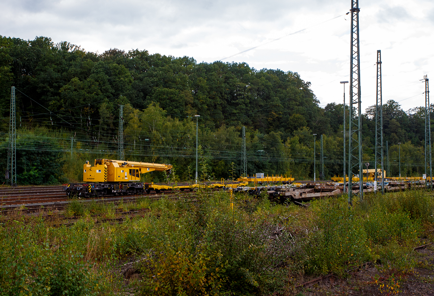Der 125 t KIROW Gleisbauschienenkran KIROW Multi Tasker KRC 810 T (mit Schwerlastausr�stung), Schweres Nebenfahrzeug Nr. D-HGUI 99 80 9419 024-1, ex 97 82 53 513 19-3, der HERING Bahnbau GmbH (Burbach) ist am 28 September 2025 im Rbf Betzdorf/Sieg abgestellt. 

Vor dem Kran sind die vierachsige (2 x 2-achsige) lange Flachwageneinheit mit abgesenktem Fu�boden (ohne Radvorlegern) 27 80 4348 084-9 D-HGUI, der Gattung Laadkks (TWA 850 RV), sowie davor der Drehgestell-Flachwagen 37 80 3999 048-6 D-HGUI, der Gattung Res, als Schutzwagen zum Kran (u.a. beladen mit der Traverse, Anschlagmittel und sonstiges Zubeh�r).
