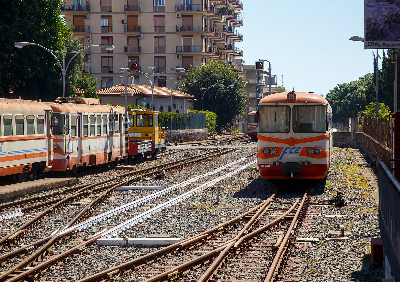 Der 950mm-Schmalspur-Dieseltriebwagen RAL 6405 der Ferrovia Circumetnea (FCE) abgestellt am 17.07.2022 beim Bahnhofes Catania-Borgo. Links steht der ältere Dieselelektrische Triebwagen FCE ADe 08, ex FCL (Ferrovie Calabro Lucane) M4 De 152 (serie M4 De 150). Obwohl sonntags der Bahnbetrieb hier ruht, habe ich es nicht gewagt den Abstellbereich zu betreten und nur Bilder vom Bahnsteig gemacht.

Die FCE RALn 64 Triebwagen sind eine Gruppe von sechs Schmalspur-Dieseltriebwagen der Ferrovia Circumetnea (FCE), die durch Umbau und Modernisierung aus sechs ehemaligen Triebwagen der italienischen Staatsbahn FS der Gruppe RALn 60 endstanden. Die RALn 60 wurden 1949–50 von Fiat gebaut, um die Dampftraktion abzulösen. Sie wurden auf den meistfrequentierten Strecken des sizilianischen Schmalspurnetzes eingesetzt. 1971 wurden sechs Triebwagen an die Ferrovia Circumetnea verkauft, die ab 1981 zu diesen RALn 64 umbaute.

TECHNISCHE DATEN (der RAL 64):
Spurweite: 	950 mm
Achsformel: B’B’
Höchstgeschwindigkeit: 90 km/h
Länge über Puffer: 19.220 mm
Höhe: 3.330 mm
Breite: 2.590 mm
Drehzapfenabstand: 12.500 mm
Achsstand im Drehgestell: 2.000 mm
Raddurchmesser: 720 mm (neu)
Leergewicht: 28,7 t 
Dienstgewicht: 35,2 t 
Dieselmotor: Fiat 8217.12.04
Installierte Leistung: 2 × 185 kW
Kraftübertragung: mechanisch
Getriebe: mechanisches 5-Gang-Getriebe mit hydraulischer Gelenk-Trocken-Zweischeibenkupplung
Sitzplätze: 	64

Die FCE ADe 07 bis 10 sind eine Gruppe von vier, ehemaligen FCL M4 De 151-154 (Serie M4 De 150) Dieselelektrische Triebwagen, die 1978 erworben wurden. Die FCL - Ferrovie Calabro Lucane, war eine Gesellschaft die in den vier süditalienischen Regionen Kampanien, Basilikata, Apulien und Kalabrien, Schmalspurbahnen betrieb.

Die 4 Triebwagen wurden 1968 von der Officine Meccaniche della Stanga von FCL in Auftrag gegeben. Die Triebwagen wurden nach dem klassischen Schema von Stanga gebaut, mit elektrischem Antrieb, geliefert von Tecnomasio Italiano-Brown-Boveri (TIBB). Bereits in den 1970er-Jahren wurden bei der FCL Strecken eingestellt, so wurden die Triebwagen nach Sizilien an die Ferrovia Circumetnea (FCE) verkauft, die sie als ADe 07-10 registrierte. Bei der FCL hätte es noch Einsatzgebiete gegeben, aber man setzte traditionell doch eher auf Triebwagen mit mechanischen oder hydraulischen Getriebe. Darüber hinaus waren die M4 De 150 durch ihre reduzierte Leistung begrenzt, die das Ziehen von Wagen auf allen Strecken nicht erlaubte.

TECHNISCHE DATEN (der Ade, ex Serie M4 De 150):
Hersteller: OMS (mecha.) / TIBB (elektrisch) / unter Beteiligung von FIAT
Inbetriebnahme: 1970 (FCL) / 1978 (FCE)
Spurweite: 	950 mm
Achsformel: B’B’
Länge über Puffer: 18.250 mm
Höhe: 3.350 mm
Breite: 2.450 mm
Drehzapfenabstand: 10.500 mm
Achsstand im Drehgestell: 2.100 mm
Raddurchmesser: 750 mm (neu)
Leergewicht: 28,8 t 
Dienstgewicht: 39,8 t 
Dieselmotor: 6-Zylinder FIAT-Dieselmotor vom Typ 221H 0710/4
Installierte Leistung: 2 × 136 kW
Höchstgeschwindigkeit: 75 km/h
Kraftübertragung: elektrisch
Sitzplätze: 	52
