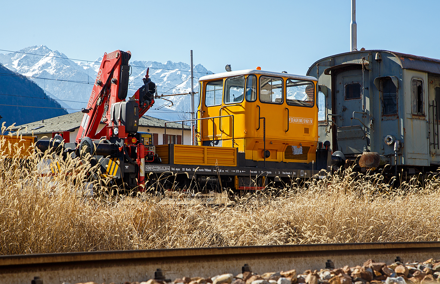 Der Italienische Rottenkraftwagen mit Kran/ Motocarrello di servizio con gru a bracci, F D AGR MI 5161 V (ähnlich einem Klv 53 der DB) mit dem zweiachsigem Gleiskraftwagenanhänger WD CRR MI 0098 L abgestellt am 19 Februar 2017 in Tirano, leider hier im Gegenlicht. Rechts der Steuerwagen FS pBz 623 327 zu den Triebwagen der Baureihen E.623 (Automotrice elettrica E.623 - Rimorchi pBz 623).

Der Klv 53 (Kleinwagen mit Verbrennungsmotor 53) zählte bei der DB ursprünglich zu den meistgebauten Arbeitszugfahrzeugen. Im Rahmen von Modernisierungs- und Umstrukturierungsmaßnahmen wurden und werden viele der inzwischen etwas angejahrten Fahrzeuge an private Gleis- und Oberleitungs-Baufirmen sowie Privatbahnen im In- und Ausland verkauft und sind dort nach einer meist gründlichen Aufarbeitung und Detail-Umbauten nach wie vor im Einsatz. Dieses Fahrzeug hat einen Kran vom Italienischen Hersteller FASSI (Typ Fassi F 150), bei den DB Klv 53 wurden Ladekrane von Atlas oder Meiller verwendet. Zudem hat das Italienische Fahrzeug wie auch der Wagen hier (schwere) Hülsenpuffer, so sind diese Fahrzeuge auch etwas länger.

TECHNISCHE DATEN vom Klv: 
Spurweite: 1.435 mm (Normalspur)
Achsformel: B
Länge über Puffer: 7.060 mm
Achsabstand: 3.750 mm
Treibraddurchmesser: 700 mm (neu)
Höchstgeschwindigkeit : 55 km/h
Eigengewicht: 11 t 
Nutzlast: 2 t