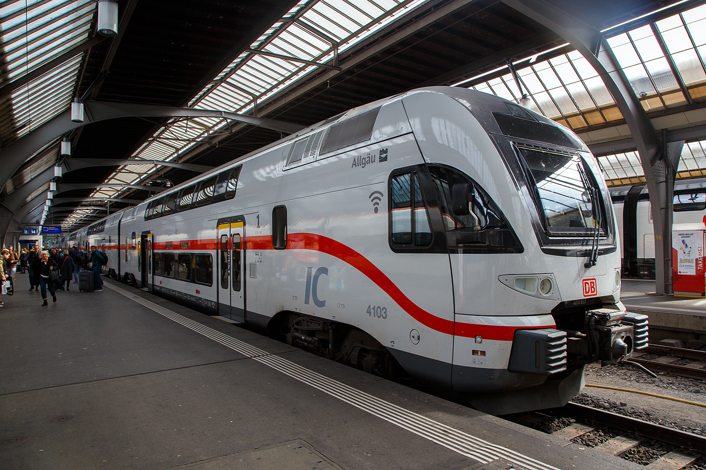 Der sechsteilige Stadler KISS 4010 103 (93 85 4010 103-8 CH-DB ff)  IC2 4103  Allg�u  der DB Fernverkehr AG (ein ex Westbahn KISS) hat als IC 485 von Singen(Hohentwiel) am 21.03.2023 Z�rich HB erreicht.

 KISS  - das hei�t: Komfortabler Innovativer Spurtstarker S-Bahn-Zug.

Nicht nur die DB Regio AG setzt auf die  KISS -Doppelstockz�ge des Schweizer Herstellers Stadler Rail bzw. Stadler Pankow, auch DB Fernverkehr erweitert seine Intercity 2-Flotte durch den Kauf von 17 hochwertigen gebrauchten Doppelstockz�gen dieses Typs, die bisher bei der �sterreichischen Westbahn im Einsatz waren. Die Fahrzeuge sind gr��tenteils erst zwei Jahre alt und haben bei den Kunden in �sterreich h�chste Zufriedenheitswerte erreicht.

Urspr�nglich wurde das Fahrzeugkonzept f�r S-Bahnen entwickelt. L�ngst ist die KISS-Plattform aber weiterentwickelt worden f�r schnelle Regional-Express-Linien und es gibt sogar eine Fernverkehrsvariante mit sehr komfortabler Innenausstattung und einer Druckert�chtigung f�r das Befahren von Tunnels mit 200 km/h und einem entgegenkommenden 300 km/h-Zug. Mit einer S-Bahn hat das nur noch in einer Disziplin zu tun: N�mlich eine enorm gute Beschleunigung!

Was k�nnen diese Neuerwerbungen:
Die hochwertigen Kiss-Z�ge, die bisher bei der Westbahn fuhren, sind bis zu 200 km/h schnell und bestehen aus vier bzw. sechs Wagen. Nach den Anpassungen f�r den Intercity-Einsatz verf�gen sie �ber rund 300 bzw. 470 Sitzpl�tze. Auf zwei Etagen gibt es komfortable Sitzlandschaften und viel Bewegungsfreiheit. Die Fahrzeuge sind mit WLAN und Steckdosen (je Sitzplatz eine) ausgestattet sowie einem modernen Fahrgastinformationssystem. Auch ein gastronomischer Service mit hei�en und kalten Getr�nken, s��en und herzhaften Snacks sowie frischen Baguettes ist vorgesehen: Unsere G�ste werden die Wahl haben, ob sie sich am Platz bedienen lassen oder ob sie es sich in einem der beiden Caf�bereiche gem�tlich machen. Die vorhandenen Bereiche f�r Reisende mit Mobilit�tseinschr�nkungen, f�r Gep�ck und Fahrr�der werden entsprechend �blicher DB-Standards sukzessive erweitert.

TECHNISCHE DATEN:
Erste Inbetriebnahme: Dezember 2022
Anzahl der Z�ge: 8 (7x 1. Bau Serie & 1x 2. Bau Serie)
Zugl�nge: 150 m
Anzahl angetriebener Achsen: 8
Zugleergewicht: 316 t
H�chstgeschwindigkeit:200 km/h
Auslandseinsatz m�glich: ja (A, CH)
Sitzpl�tze: 486 (inklusive 19 Klappsitze), davon 62 in 1. Klasse
Fahrradstellpl�tze: 8
Kinderwagenstellpl�tze: 2
