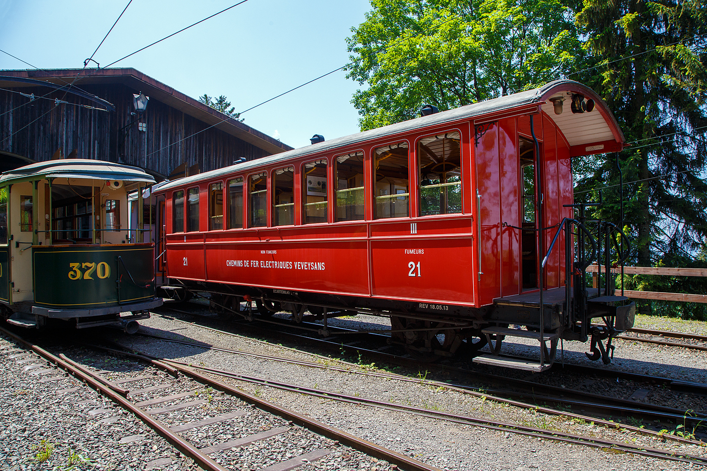 Der sehr sch�ne ex CEV zweiachsige  2. Klasse (Nichtraucher) / 3. Klasse (Raucher) Gro�raum-Plattformwagen BC� 21 der Museumsbahn Blonay-Chamby, ex Chemins de fer Electriques Veveysans - CEV BC� 21, am 27.05.2023 im Museum Caulin. 

Der Wagen wurde 1902 von der SWS (Schweizerische Wagons- und Aufz�gefabrik AG, Schlieren) f�r die Chemins de fer �lectriques Veveysans (CEV) gebaut und als CEV BC� 21 geliefert. Im Jahr 1971 ging der Wagen an die Museumsbahn Blonay-Chamby.

Die Chemins de fer �lectriques Veveysans (CEV) waren eine Schweizer Schmalspurbahngesellschaft, deren Nachfolgegesellschaft die heutige Transports Montreux–Vevey–Riviera (MVR) ist. Sie war (bzw. die MVR ist) der Betreiber der Vevey–Saint-L�gier–Blonay–Les Pl�iades sowie der Bahnstrecke Blonay–Chamby. W�hrend die Bahnstrecke Vevey–Les Pl�iades ganzj�hrig fahrplanm��ig betrieben wird, dient die Bahnstrecke Blonay–Chamby heute nur in der Sommersaison verkehrenden Z�gen der Museumsbahn Blonay–Chamby, sowie gelegentlichen Betriebsfahrten.

TECHNISCHE DATEN:
Baujahr: 1902
Hersteller: SWS (Schweizerische Wagons- und Aufz�gefabrik AG, Schlieren)
Spurweite: 1.000 mm (Meterspur)
Achsanzahl: 2
L�nge �ber Puffer: 10.200 mm
L�nge Wagenkasten: 9.200 mm (mit Plattformen)
Achsabstand: 5.000 mm
Breite: 2.700 mm
Eigengewicht: 8,6 t
Sitzpl�tze: 40
