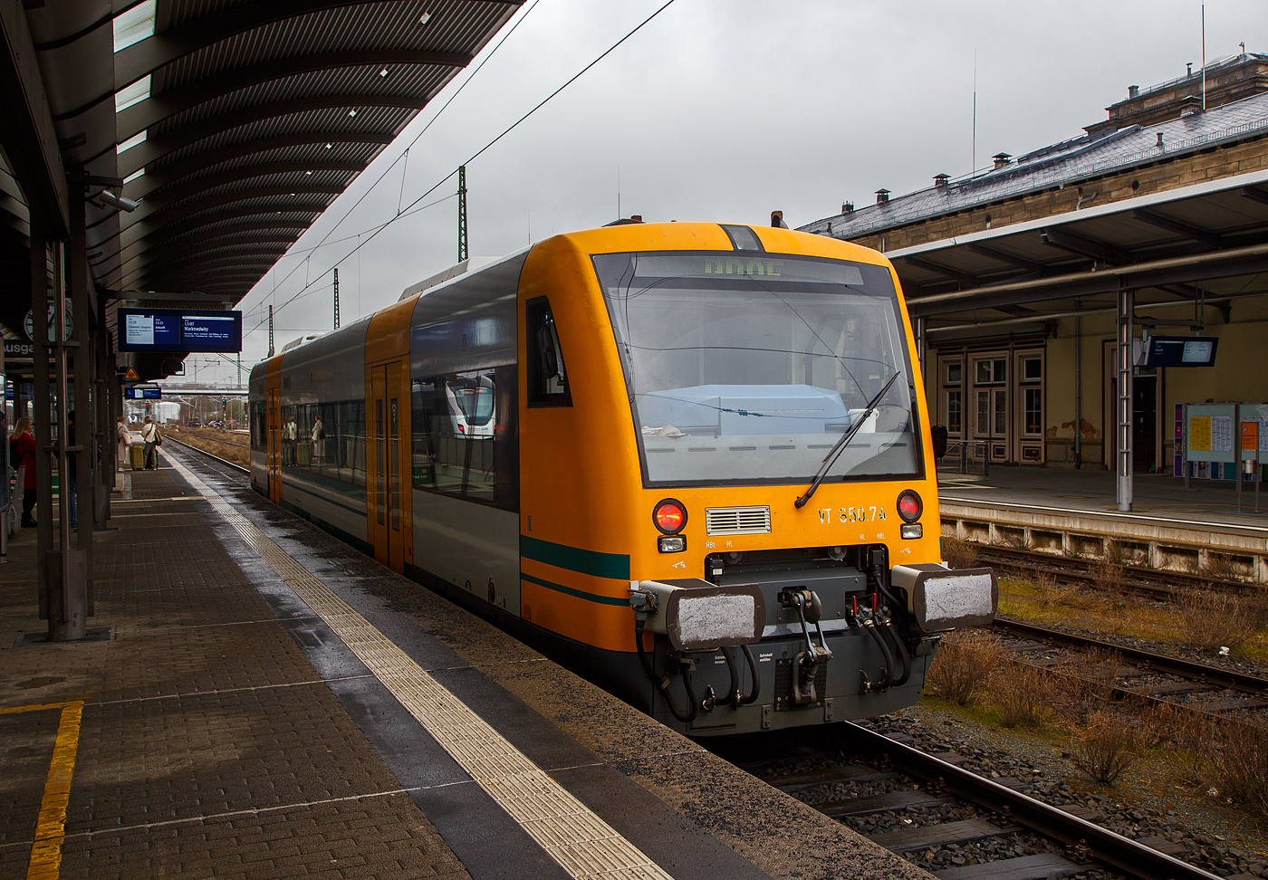 Der Stadler Regio-Shuttle RS1 – VT 650.74 (95 80 0650 074-7 D-DLB) RS1 der „oberpfalzbahn“ eine Marke der „Die L�nderbahn GmbH (DLB)“, hat am 17.04.2023, als RB 95 (Marktredwitz – Schirnding – Cheb – Hof Hbf) seinen Zielbahnhof Hof Hbf erreicht.

Der STADLER Regio-Shuttle RS1 wurde 2004von der  Stadler Pankow GmbH in Berlin unter der Fabriknummer 37313 gebaut und an die Prignitzer Eisenbahn GmbH, Putlitz (PEG). Bis 2013 war er f�r die Ostdeutsche Eisenbahn GmbH als 95 80 0650 074-7 D-ODEG „Ahrensfelde“ unterwegs. Im Jahr 2013 kaufte die Oberpfalzbahn 2 gebrauchte RS1 von der Prignitzer Eisenbahn hinzu, einer davon ist dieser. So hat die Oberpfalzbahn nun 13 STADLER RS1 im Einsatz. Im Jahr 2014 wurden alle 13 Fahrzeuge dann modernisiert. Zwischen 2015 und 2019 war er an die ČD - Česk� dr�hy a.s. als 95 80 0650 074-7 D-CD vermietet und bei der ČD in Tschechien war er als 841 074-8 gef�hrt. 