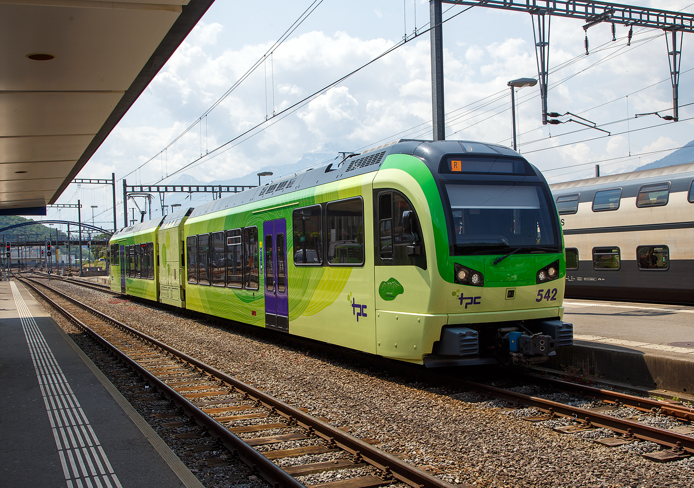 Der (TPC) AOMC/ACD Beh 2/6 542, ein Stadler SURF, steht am 28 Mai 2023 im Bahnhof Aigle zur Abfahrt nach Champéry bereit.

Wie für Stefan, gehören auch für mich die (TPC) AOMC/ACD Beh 2/6 zu den schönsten Stadler SURF Zügen. SURF steht für Série Unifiée Romande pour Réseau Ferré métrique (Einheitliche Serie für das Westschweizer Meterspurige Schienennetz). Diese ab 2015 gebaute meterspurige Triebzüge mit gemischtem Adhäsions- und Zahnradbetrieb gehören zu den Stadler GTW der 4. Generation.

