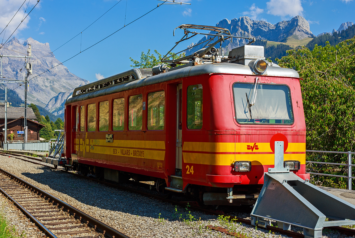 Der tpc BVB BDeh 2/4 „fl�che“ (Pfeil) 24, f�r den gemischtem Adh�sions- und Zahnradbetrieb der Bex–Villars–Bretaye-Bahn, ist beim Bahnhof Gryon ,mit dem vorgestellten Fahrradtransport-Vorstellwagen BVB Om725, abgestellt, hier am 10.09.2023. 

�brigens man kann diesen originalen Triebwagen f�r kleines Geld (f�r einen obligatorischen Preis kaufen. Da ist der Kaufpreis wohl der kleinere Anteil, die Verladung und der Abtransport sind da wohl die h�here Kosten. Die Transports Publics du Chablais muss leider die alten Zahnstangentriebwagen BDeh 2/4 „fl�che,  wie diesen Nr. 24 (Baujahr 1941) sowie die Nr. 22 (Baujahr 1940), leider entsorgen, da diese durch modernere Fahrzeuge ersetzt wurden. So kann man diese Triebwagen als Verein, Museum aber auch als Einzelpersonen von der tpc erwerben. Die letzte Revision von dem Triebwagen war im Dezember 2009.

Dieses Material muss in Bex (Schweiz) abgeholt werden. Der Spezialtransport und die allf�llige Zollabwicklung (sofern dieses Material au�erhalb der Schweiz transportiert wird) obliegen dem K�ufer. Die L�nge betr�gt ca. 15,0 Meter, die Breite 2,4 Meter und das Gewicht  20 Tonnen. Reserveausr�stung ist ebenfalls vorhanden und wird dem K�ufer zur Verf�gung gestellt. Die Ausr�stung muss vom K�ufer vor dem 29. Februar 2024 evakuiert werden. Der Verkaufspreis ist symbolisch !!!

Die BVB BDeh 2_4 „fl�che“ (Pfeil) Nr. 21 bis 26 wurden in den 1940er Jahren (1939 bis 1945), noch als BFeh2/4,von der SLM (Schweizerische Lokomotiv- und Maschinenfabrik in Winterthur) gebaut, die elektrische Ausr�stung ist von der MFO (Maschinenfabrik Oerlikon). Die Pfeile (fl�che) sind sogenannte Alleinfahrer, das hei�t sie fuhren nicht mit Steuerwagen oder in Mehrfachtraktion. Es wurden lediglich Vorstellwagen vorgesellt. 

Diese elektrischen Personentriebwagen mit Gep�ckabteil f�r den gemischtem Adh�sions- und Zahnradbetrieb, verf�gen �ber 2 Drehgestelle mit je 2 Achsen, von denen jeweils einen Achse mittels einem Motor angetrieben ist. Die somit beiden Motoren sind in Reihe geschaltet. Jeder in L�ngsrichtung angeordnete Motor treibt �ber eine Kupplung die Adh�sionsachse an. Im Zahnradbetrieb wir das Triebzahnrad dann von der Achse angetrieben. Die Triebwagen m�ssen immer Zahnradbetrieb in der gleichen Richtung stehen (der F�hrerstand 1/ Drehgestell 1 muss immer in Richtung Berg zeigen), denn die Sperrklinkenbremse wirkt nur in einer Richtung. So m�ssen  die Triebwagen f�r Transit zwischen der Linie Bex - Villars und der
Villars – Bretaye immer Gleis 5 nehmen, um in die richtige Richtung zu finden.

TECHNISCHE DATEN:
Inbetriebsetzung: 1939 bis 1945
Spurweite: 1.000 mm (Meterspur)
Achsfolge: 1Az 1Az
Zahnstangensystem: Abt
L�nge: 15.000 mm
Breite: 2.400 mm
Treibraddurchmesser: 764 mm
Zahnrad-Teilkreisdurchmesser: 573 mm
Eigengewicht: 19,5 t
Maximales Zuggewicht (Dienstgewicht): 27 t
Sitzpl�tze: 48
Stehpl�tze: 32
Max. Ladegewicht: 1,5 t
Versorgungsspannung: 750 V 
maximal Leistungsaufnahme: 580 Ampere
Leistung im Dauerbetrieb: 180 kW
�bersetzung: 1:14,260 (Adh�sion und Zahnrad)
Max. Neigung im Adh�sionsbetrieb: 60 ‰
Max. Neigung im Zahnradbetrieb: 200 ‰
H�chstgeschwindigkeit im Adh�sionsbetrieb: 35 km/h
H�chstgeschwindigkeit im Zahnradbetrieb bei Bergfahrt: 18 km/h
H�chstgeschwindigkeit im Zahnradbetrieb bei Talfahrt: 15 km/h

Der Vorstellwagen f�r den Fahrradtransport BVB Om725 hat ein Eigenwicht von 1,6 t und eine max. Zuladung von 1,5 t.

Quelle: TPC

Die Wagenk�sten der Triebwagen haben gro�e �hnlichkeit mit den acht reinen Zahnradtriebwagen GN Bhe 2/4 (ex BChe 2/4) der ehemaligen Glion–Rochers-de-Naye-Bahn (sp�ter MTGN - Montreux–Territet–Glion–Rochers-de-Naye-Bahn, heute Teil der MVR - Transports Montreux-Vevey-Riviera). Von diesen wurden ja auch1938 f�nf von der SLM gebaut (jeweils einer folgte 1947, 1949 und 1966). Diese sind aber reine Zahnradtriebwagen und haben eine Spurweite von 800 mm.
