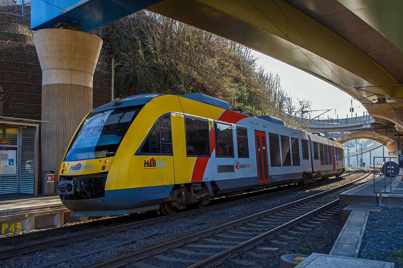 Der VT 260 (95 80 0648 160-9 D-HEB / 95 80 0648 660-8 D-HEB), ein Alstom Coradia LINT 41 der HLB (Hessische Landesbahn), als RB 90   Westerwald-Sieg-Bahn   (Limburg/Lahn – Altenkirchen – Au/Sieg - Betzdorf - Siegen - Kreuztal), am 24.03.2021 beim Halt am Hp Niederschelden Nord.

Der Haltepunkt Niederschelden Nord liegt unter der Hochstraße HTS (der B 62 neu). Danach folgt direkt der Bü 111,7 und dann die Siegbrücke.
